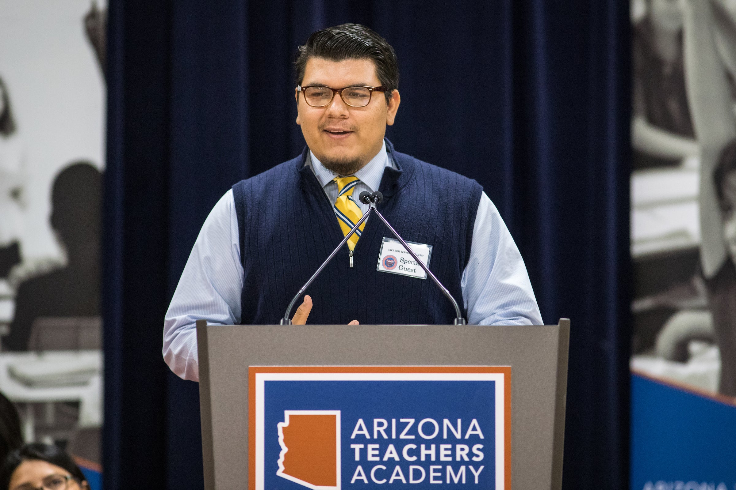 A man stands at a lectern.