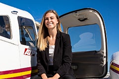 woman sitting next to small plane