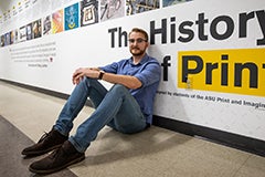 man sitting on ground leaning against wall