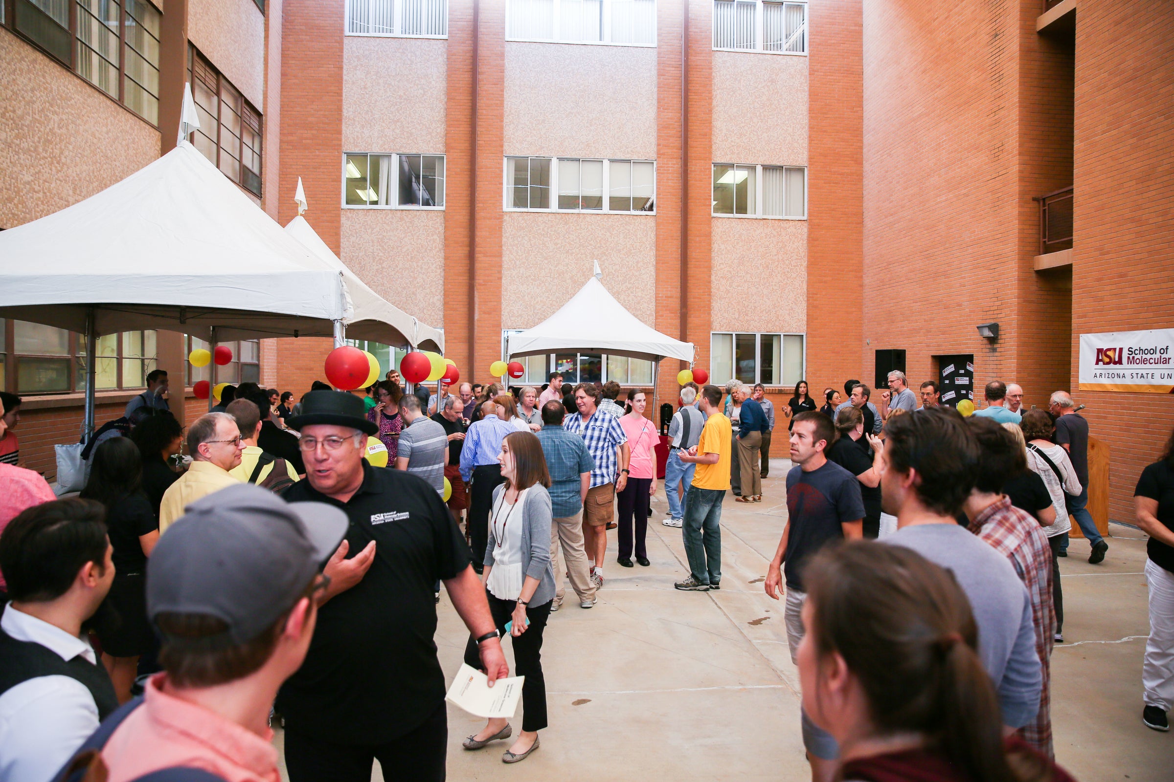 People gather in a brick courtyard for a celebration