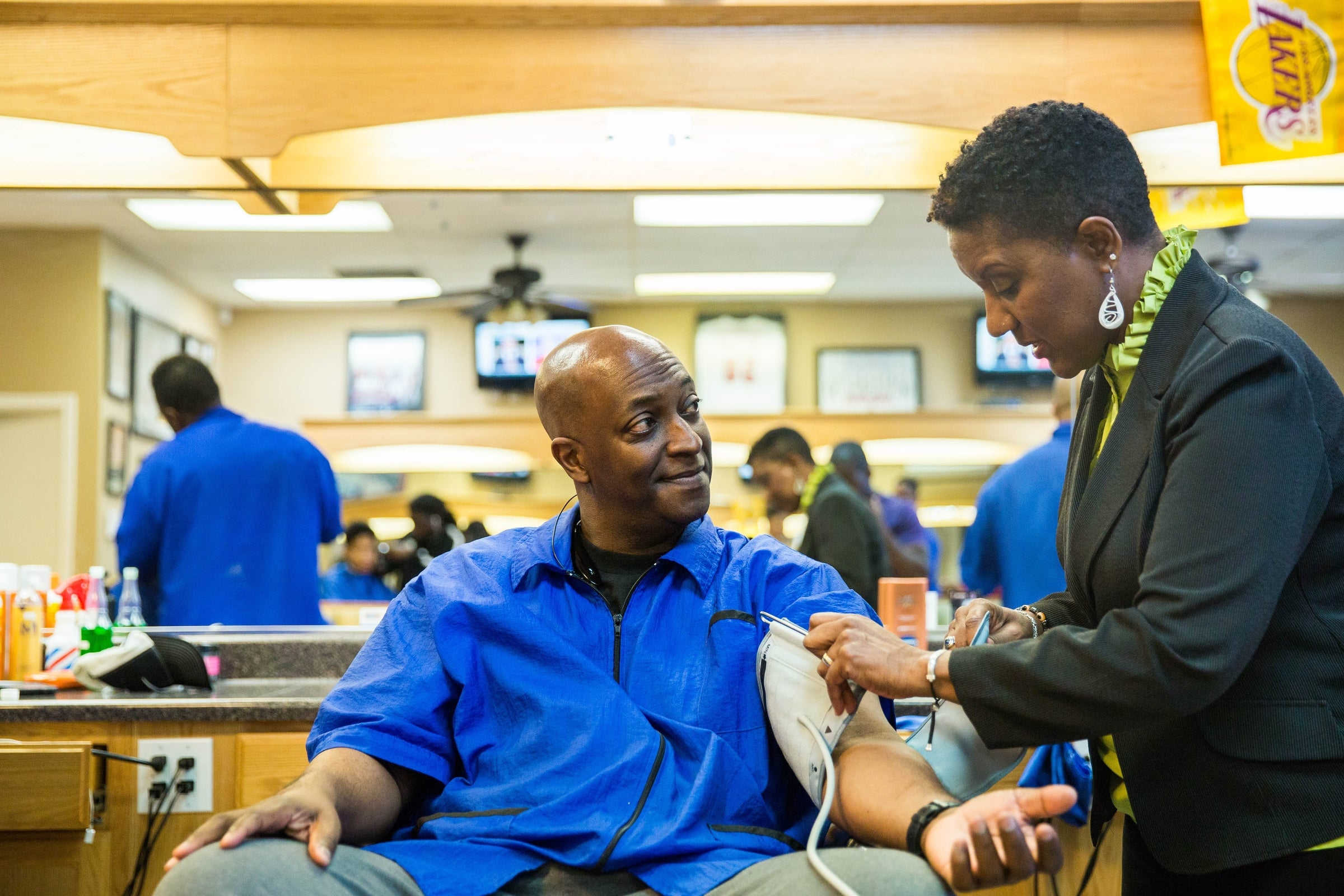 A man has his blood pressure taken at a barbershop.