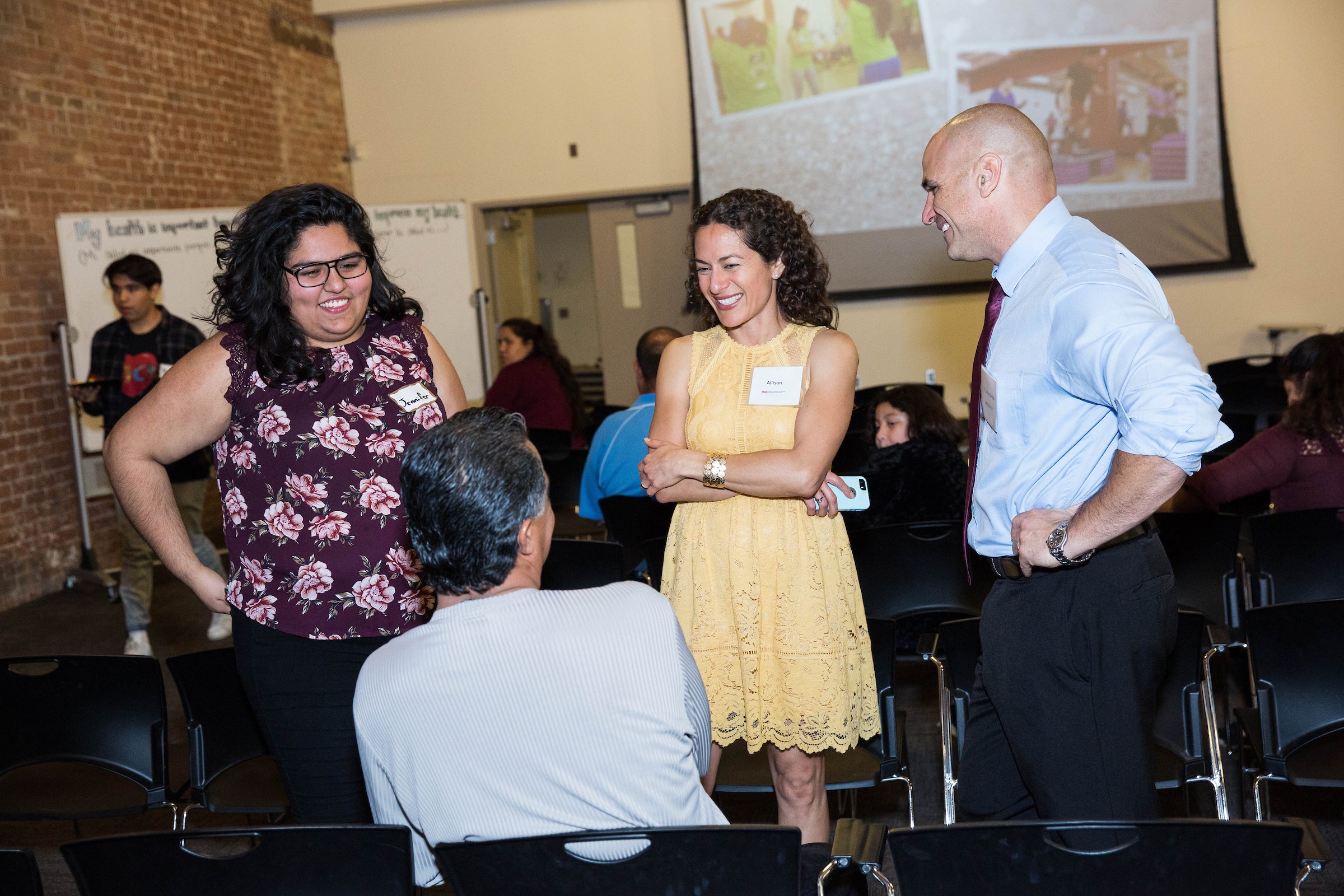 man and woman talking to audience members at community health event