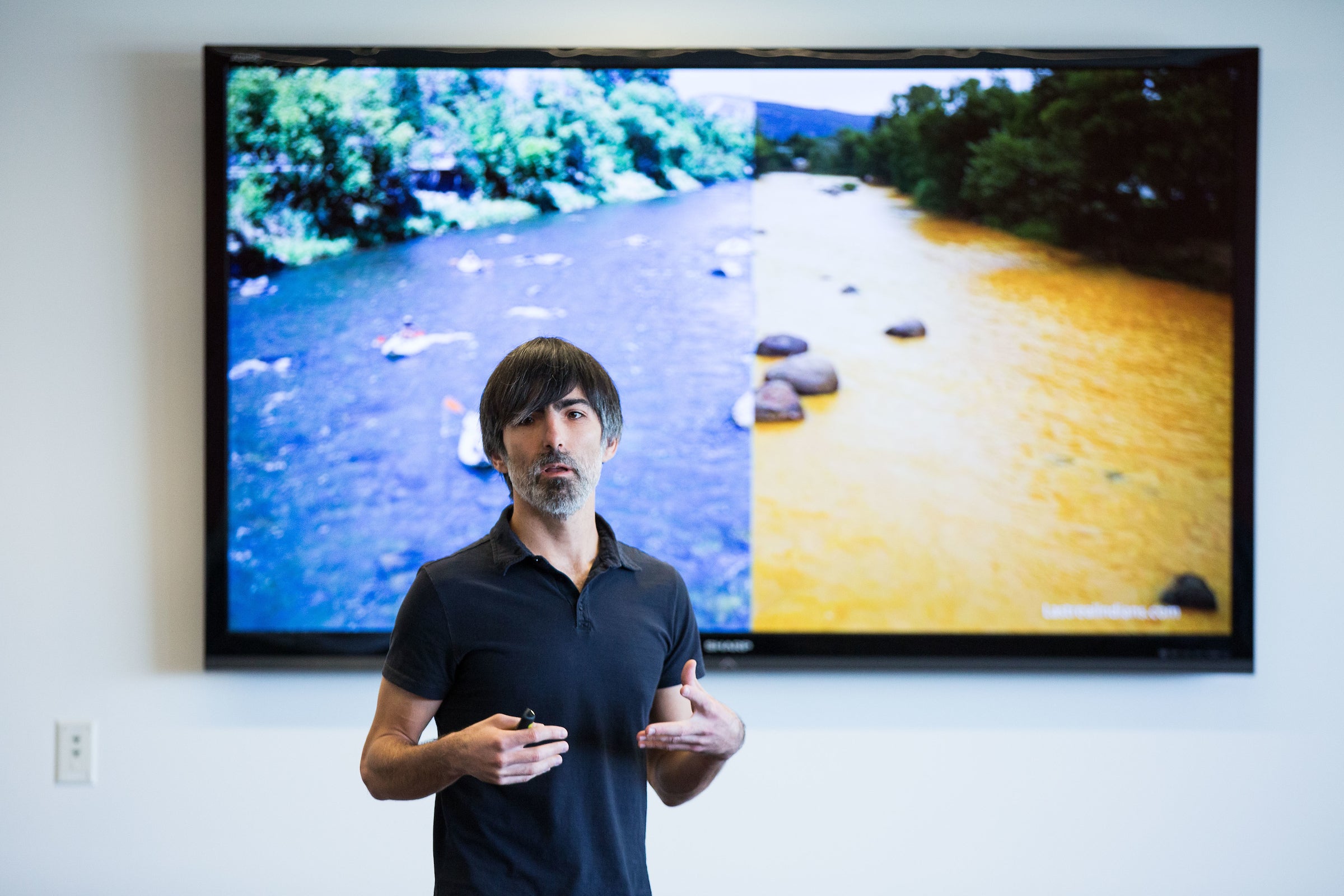 person talking in front of at TV screen