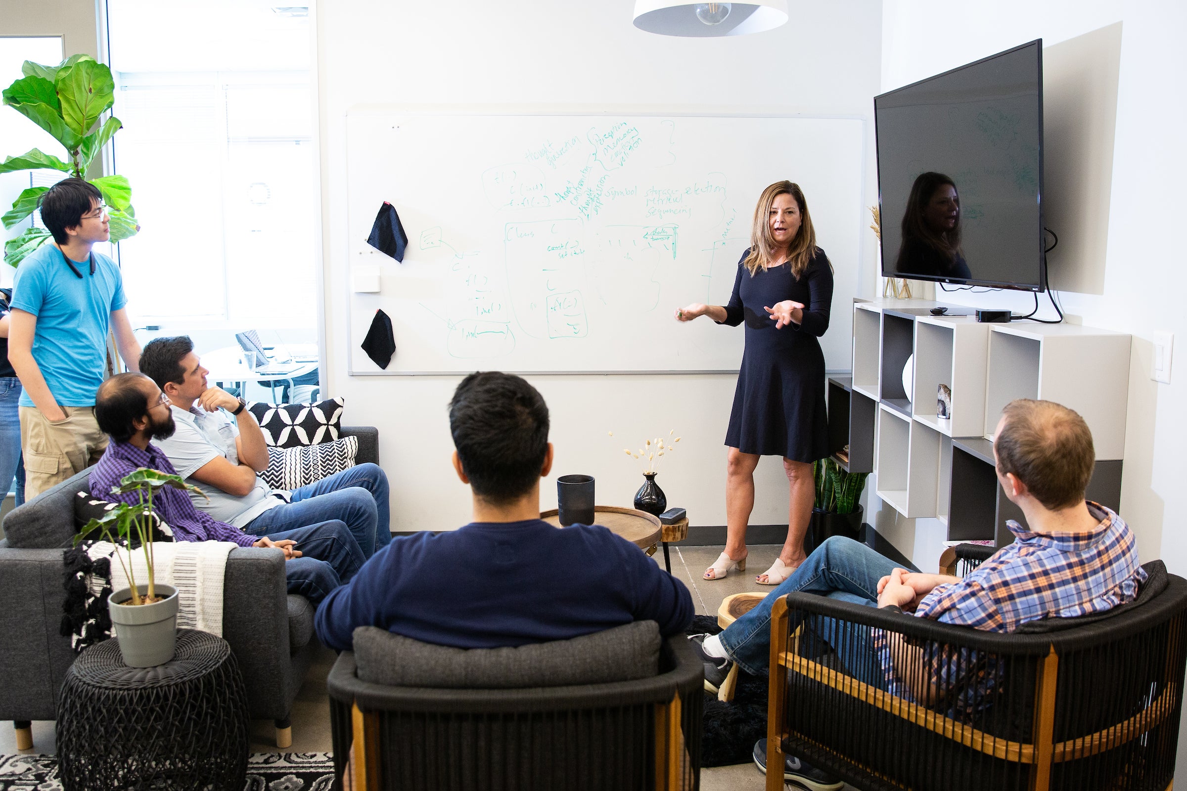 woman speaking to group of employees