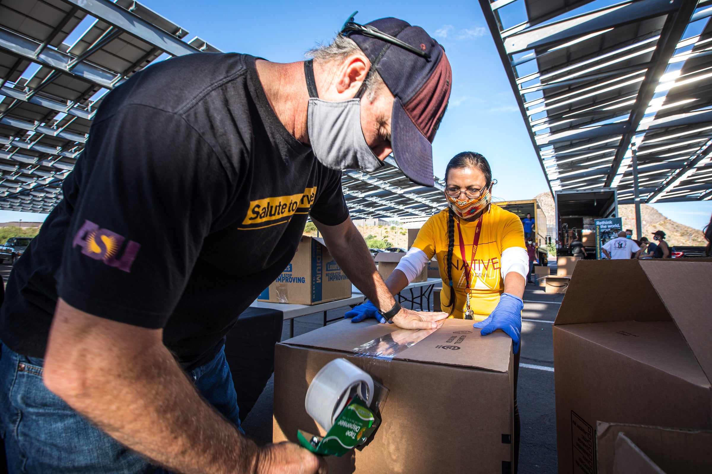 Volunteers tape up boxes of donations