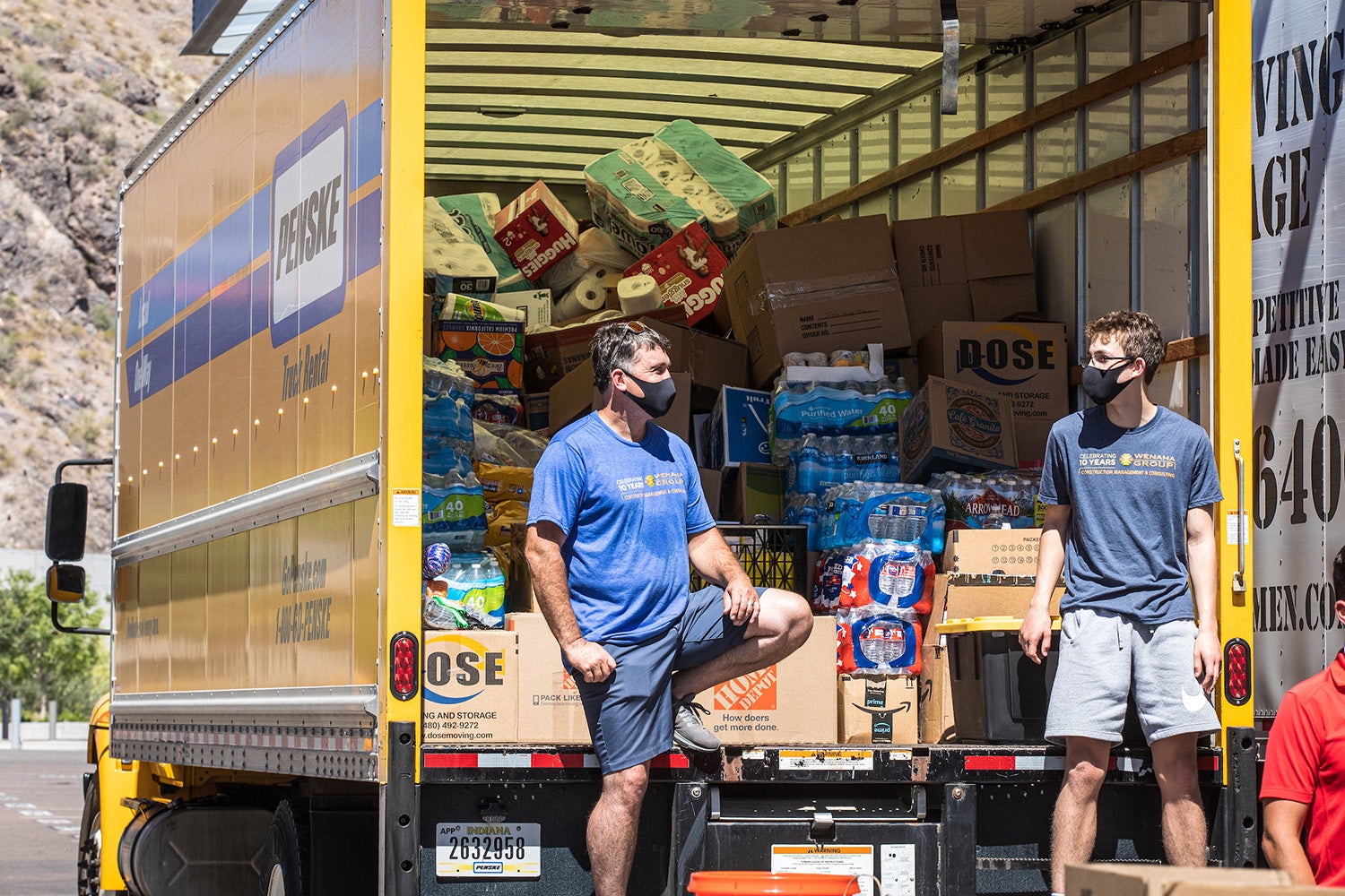 father and stepson talk in front of loaded donation truck