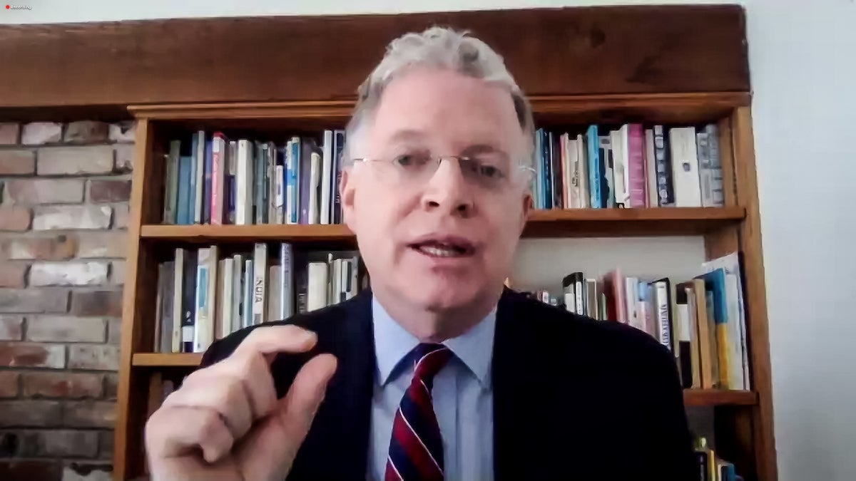 Man in glasses with bookshelf in the background