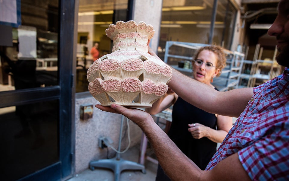 Student holding up a ceramic vase