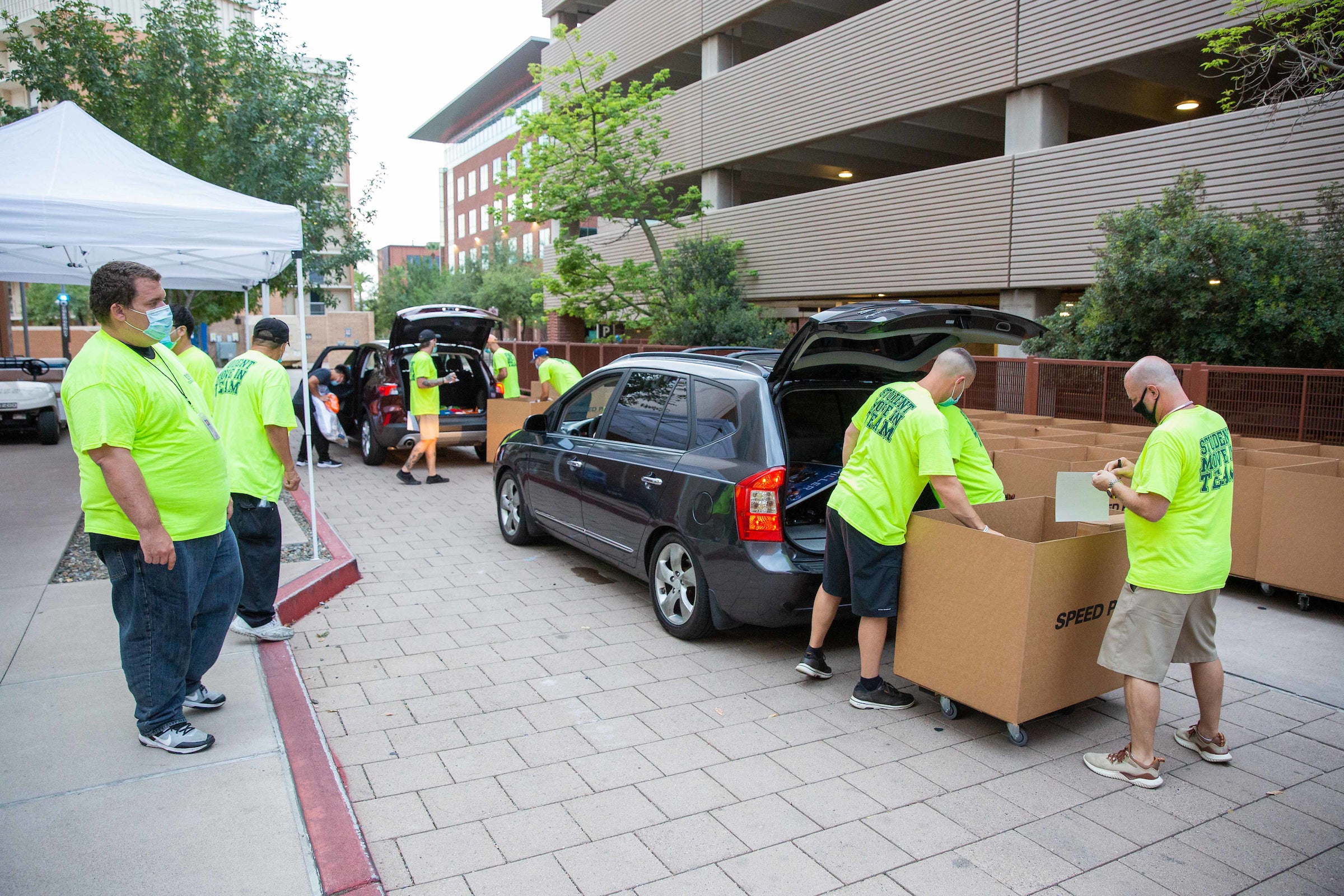 movers unpacking stuff into boxes from cars