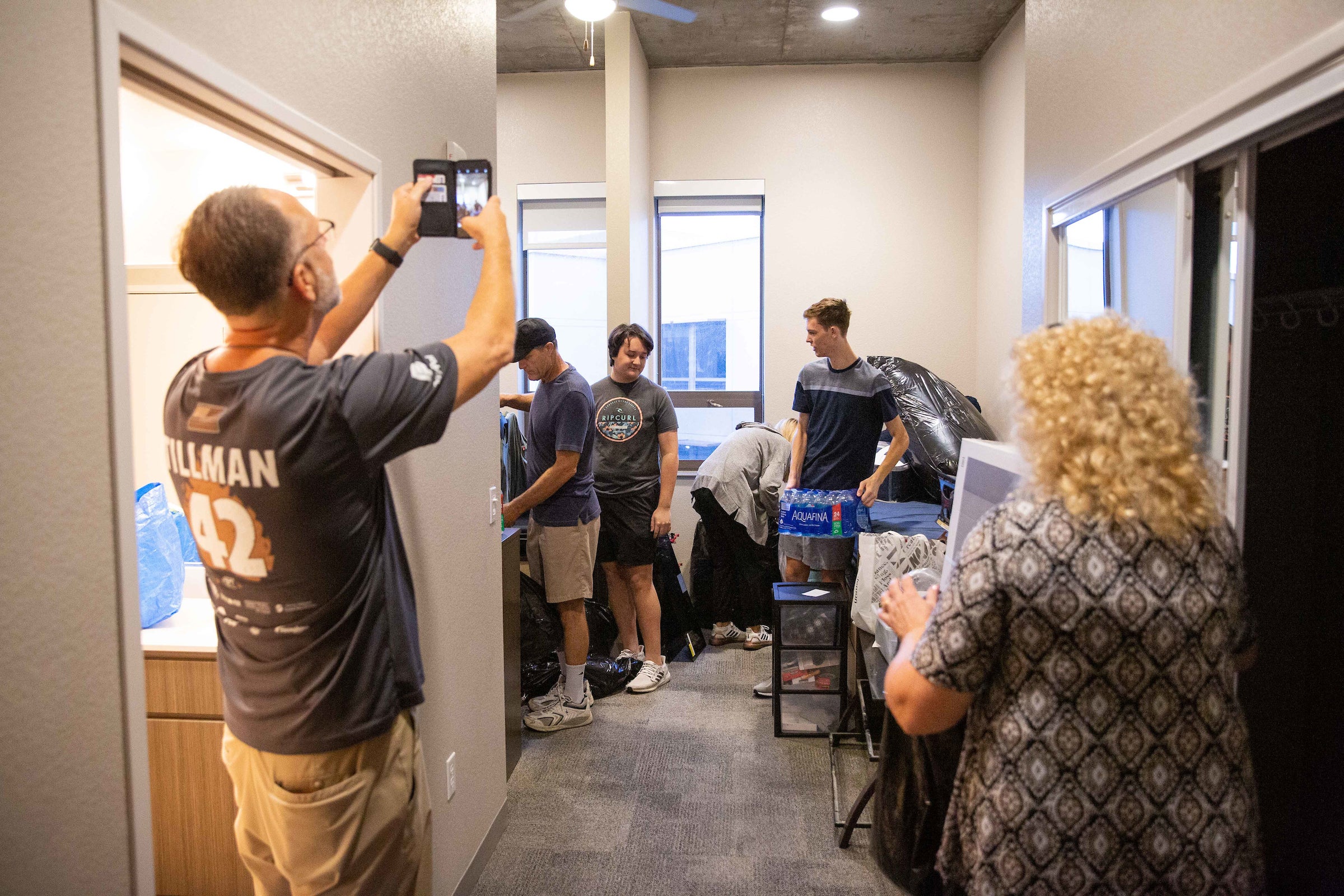 father taking photo of students moving in