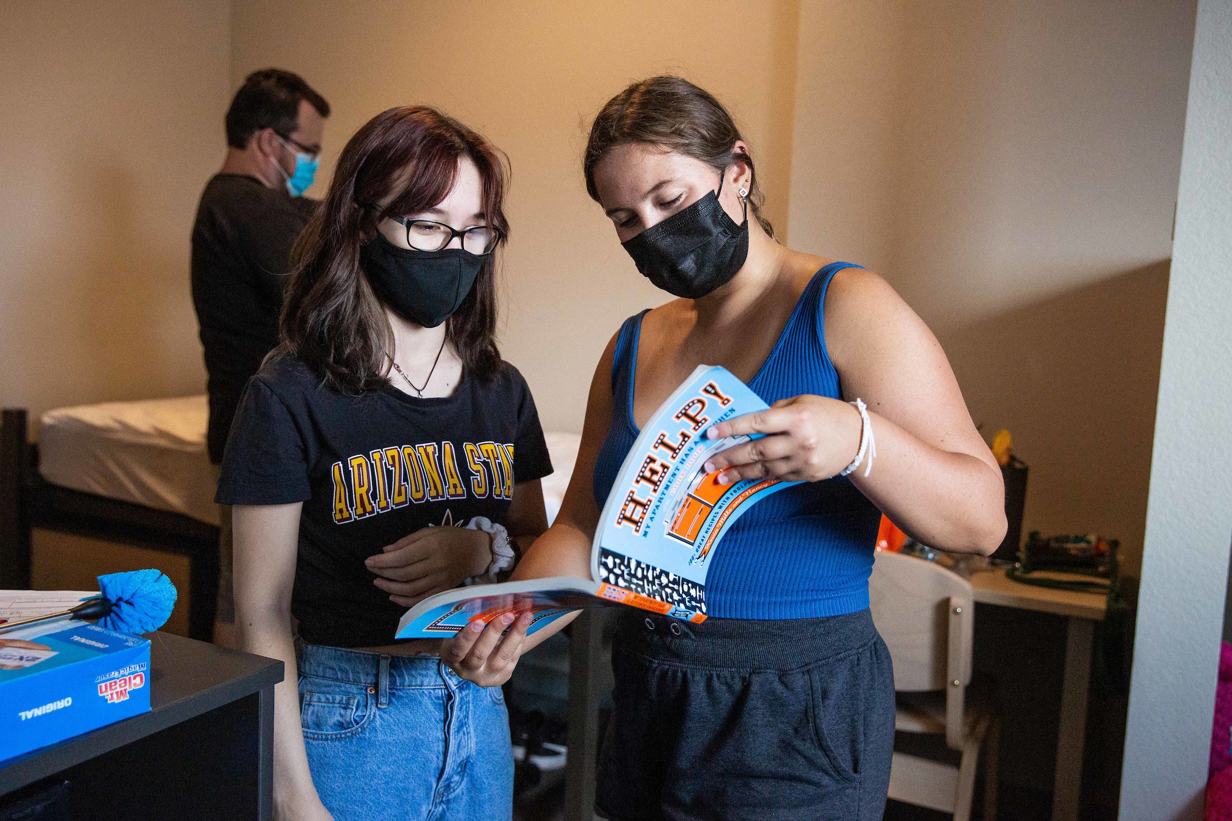 two students looking at cookbook