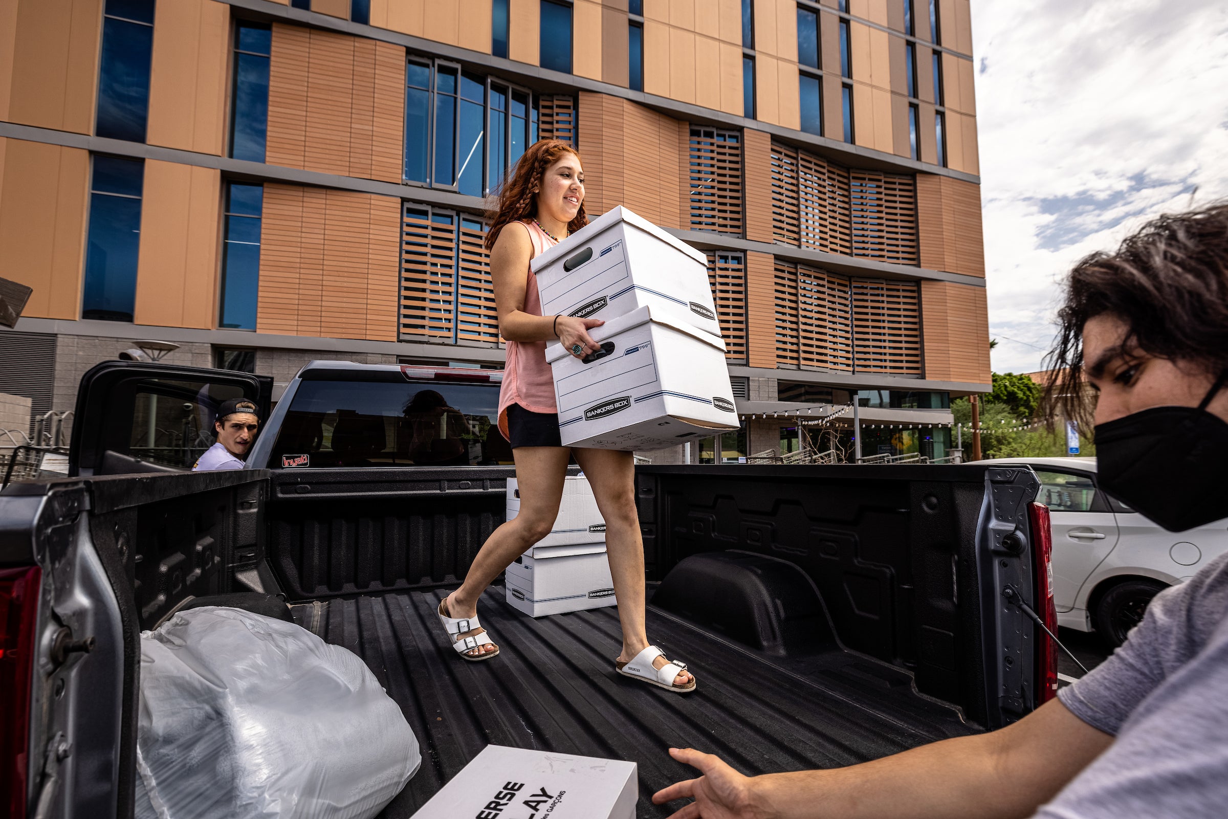 student carrying boxes off truck bed