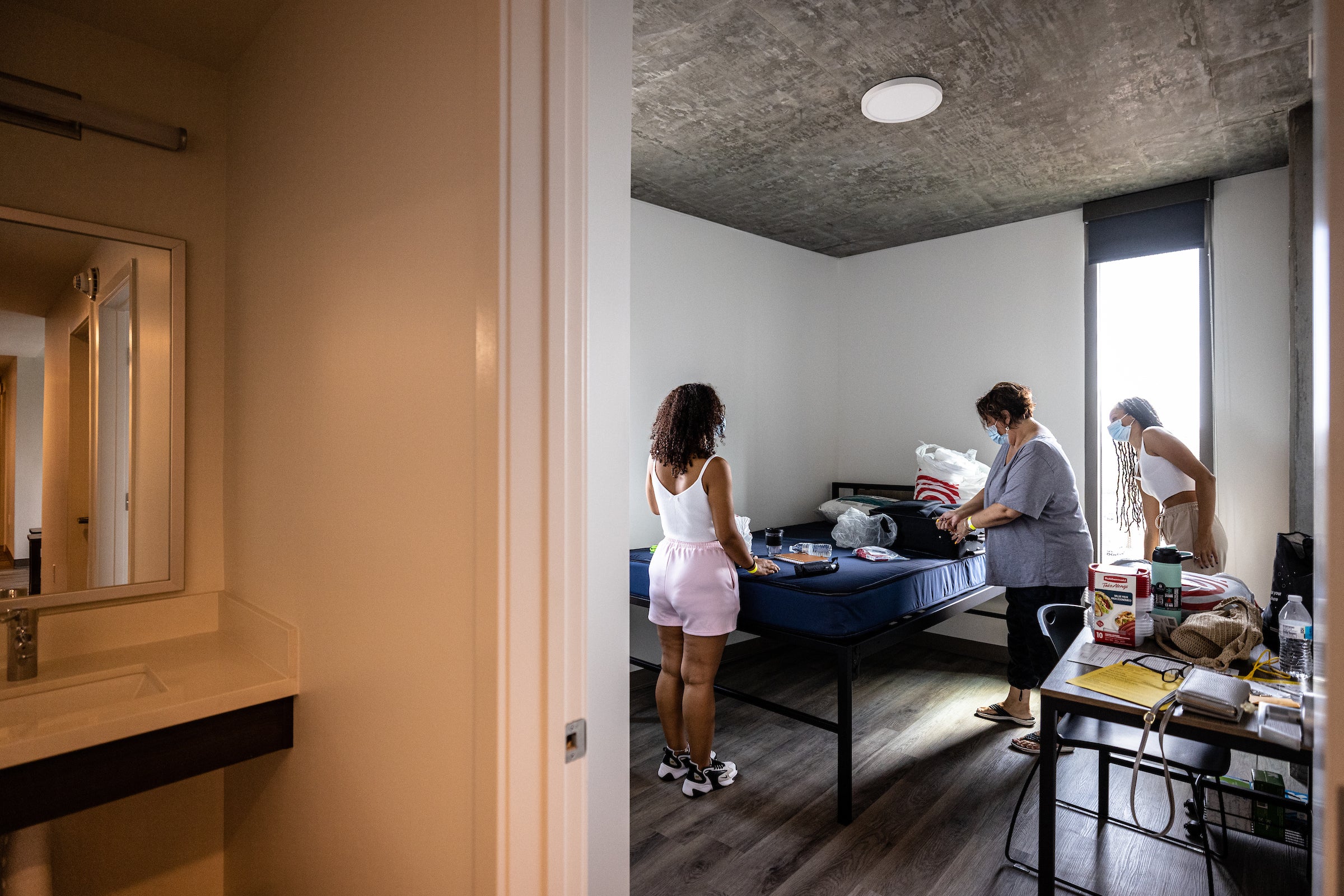 family unpacking items in dorm room