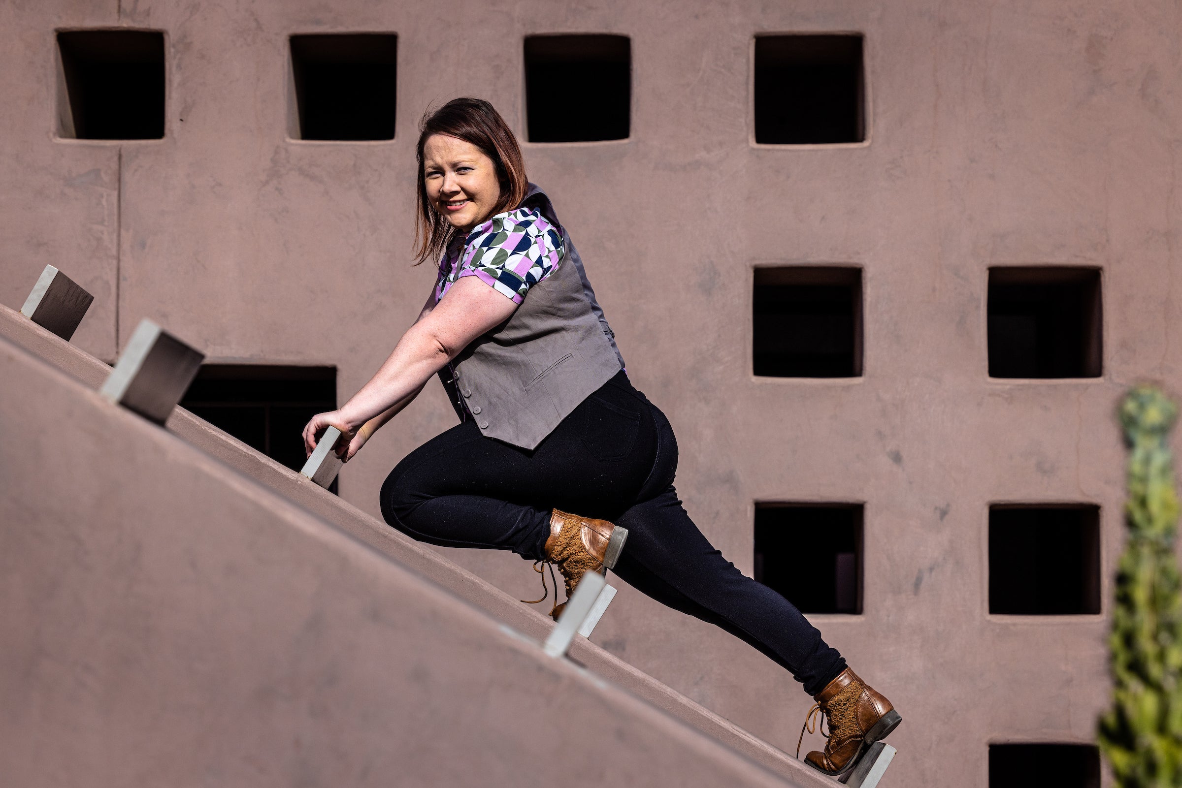 woman in a lunge pose outside arts building