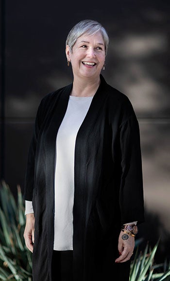 A woman looks to the right and smiles in an outdoor portrait