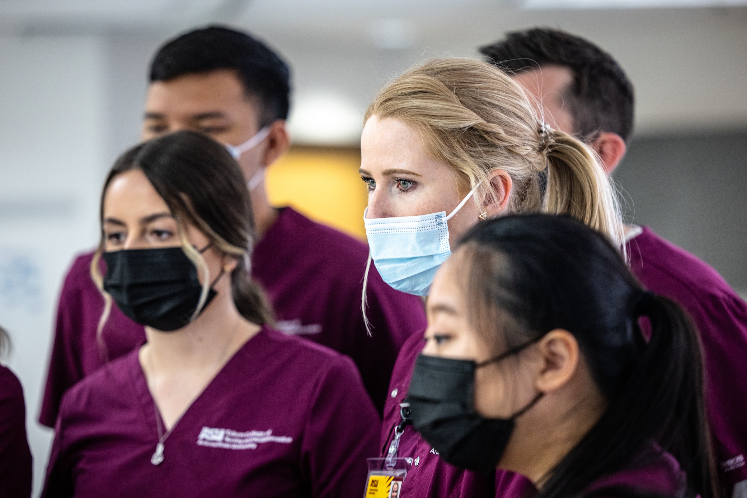 Nursing students watch an instructor go over an infusion pump 