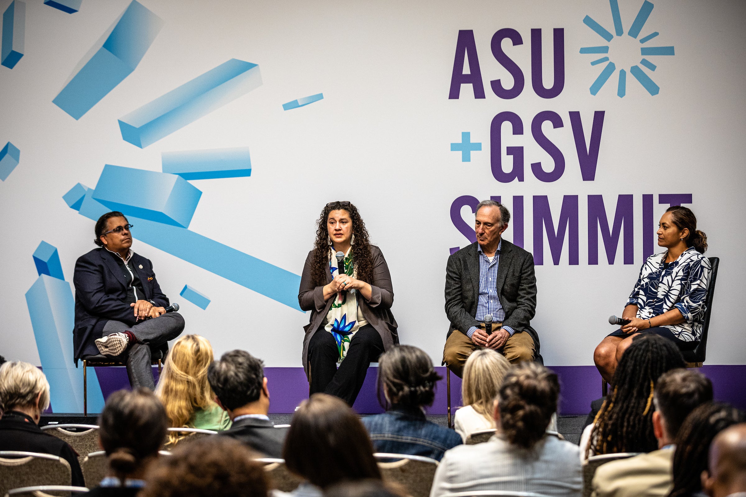 four people sitting on stage at event