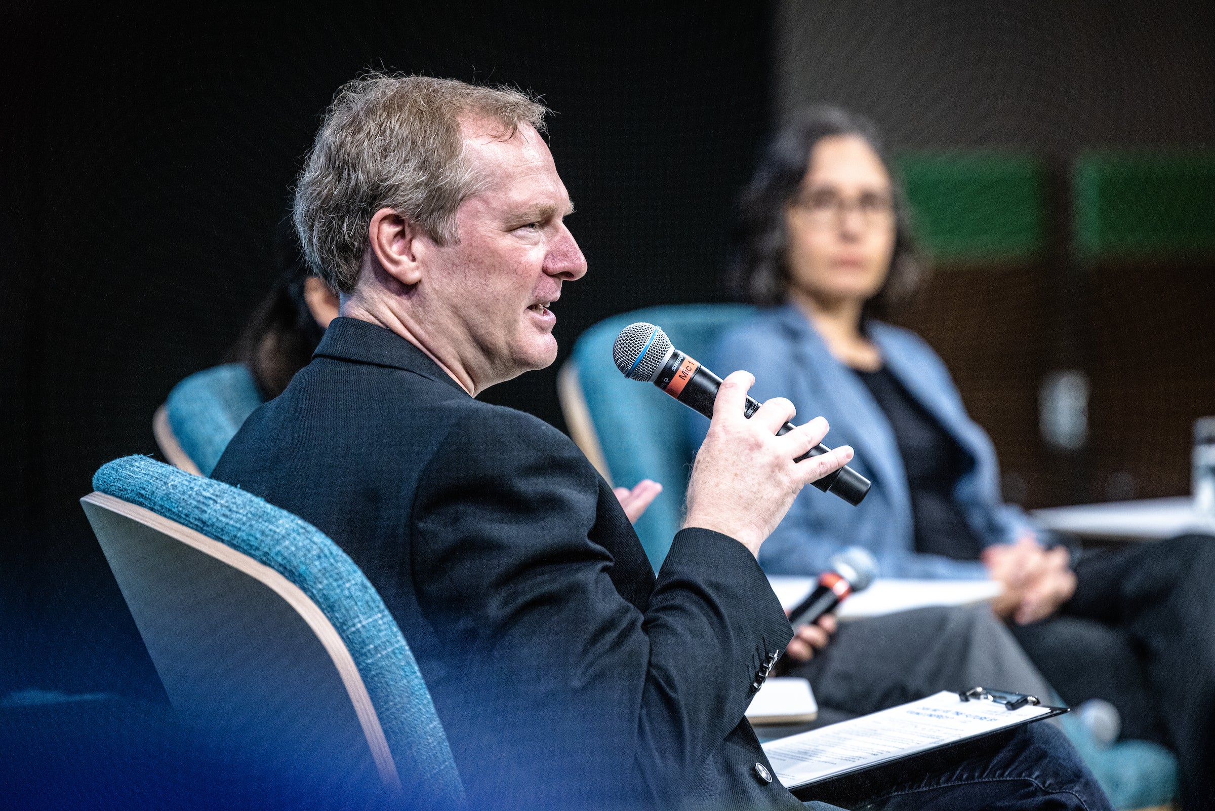 man speaking into microphone at event