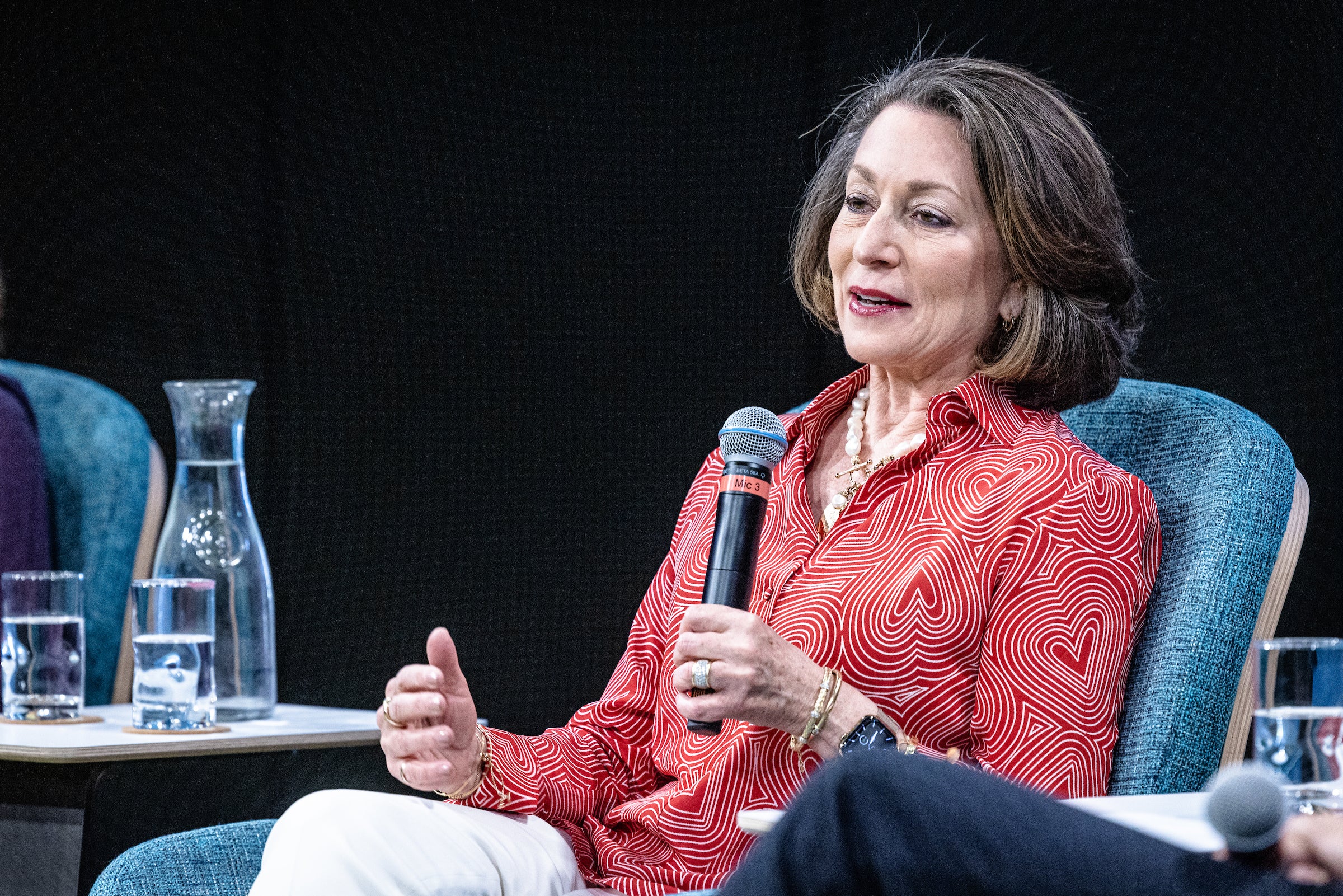 A woman on a panel speaks into a mic