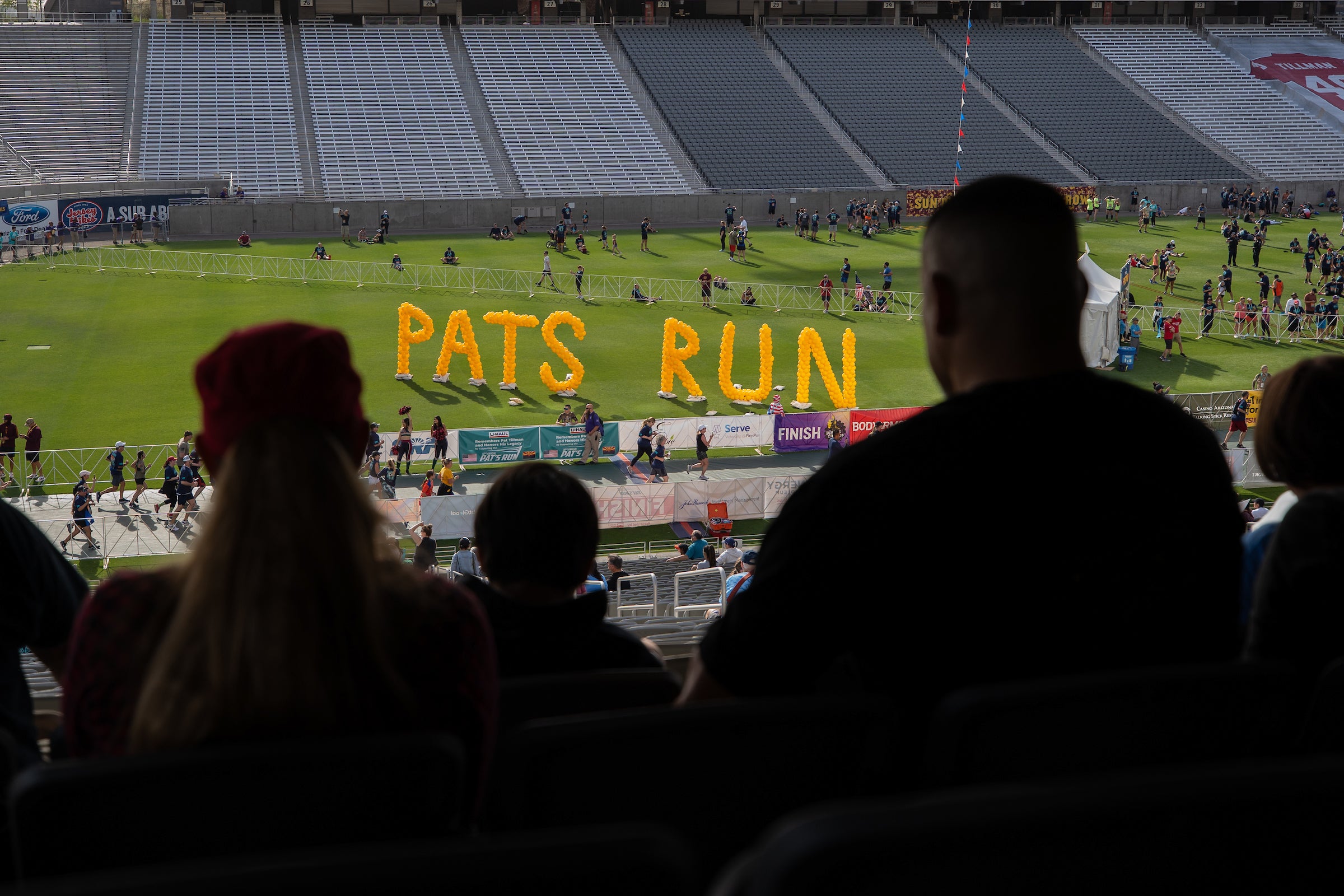 People watching runners finish at Sun Devil Stadium