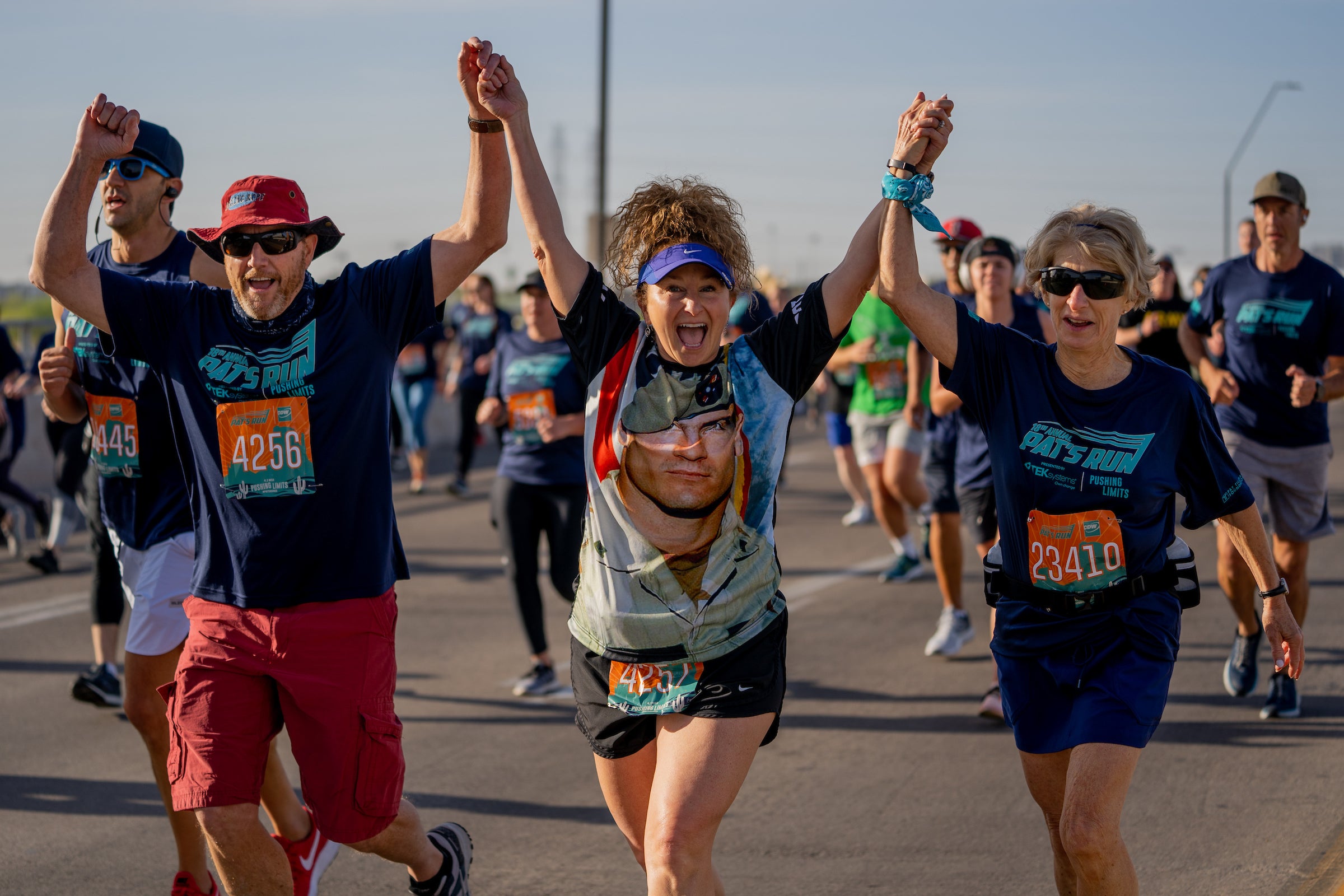 People holding hands up in air during run