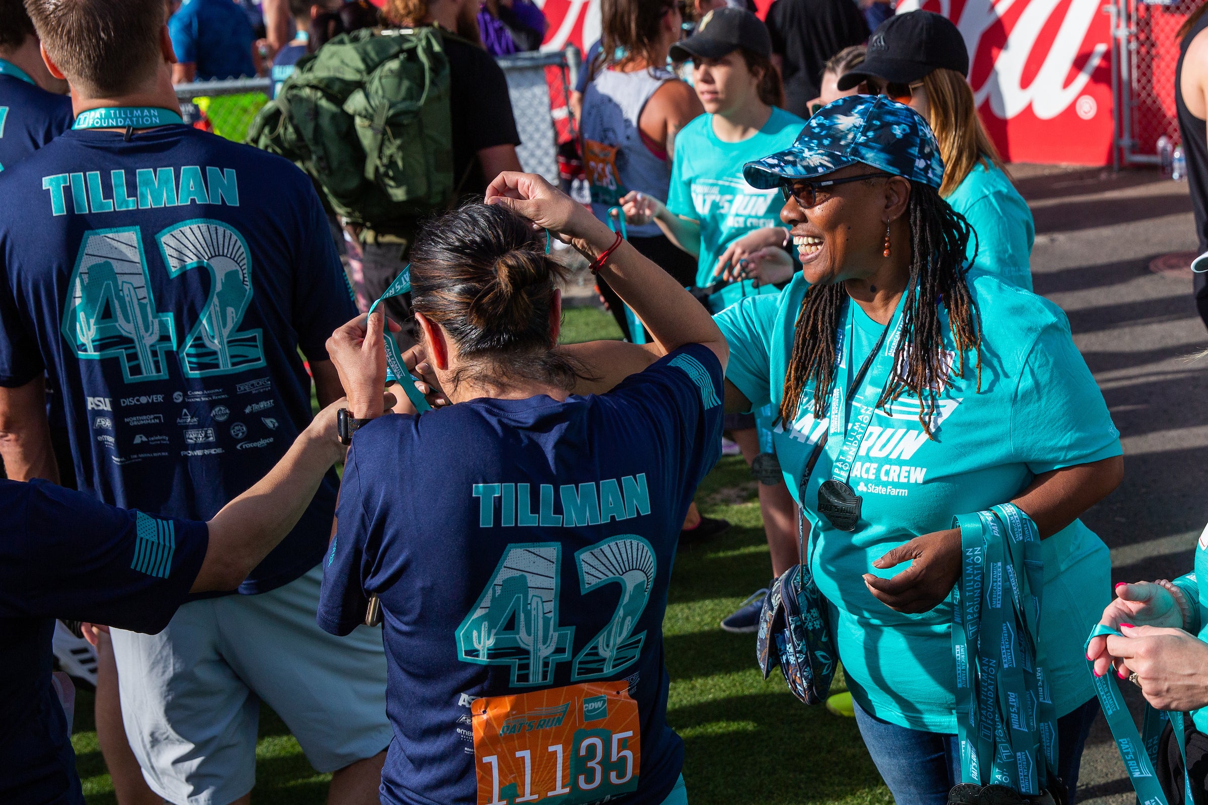 woman handing out medals to Pat's Run participants