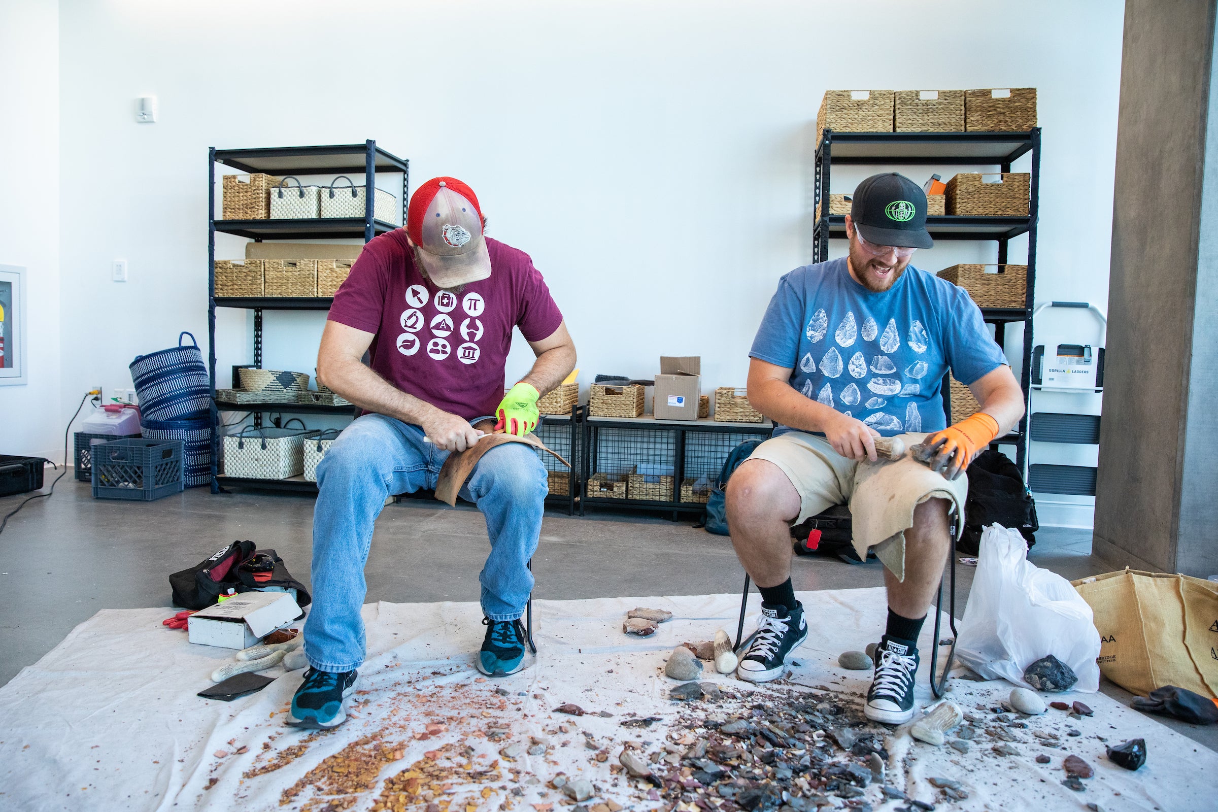 Two students making stone tools in lab