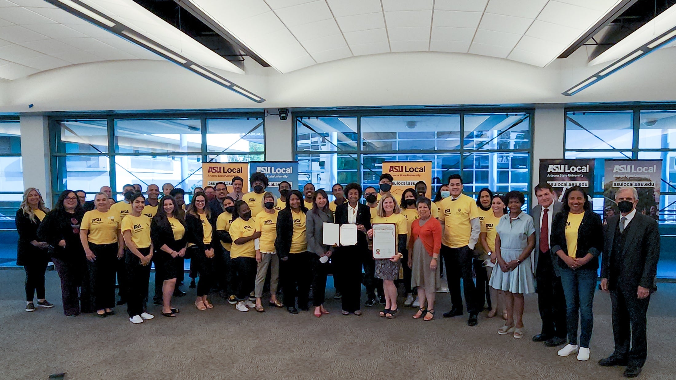 Group photo of people in a conference center wearing gold ASU Local shirts.