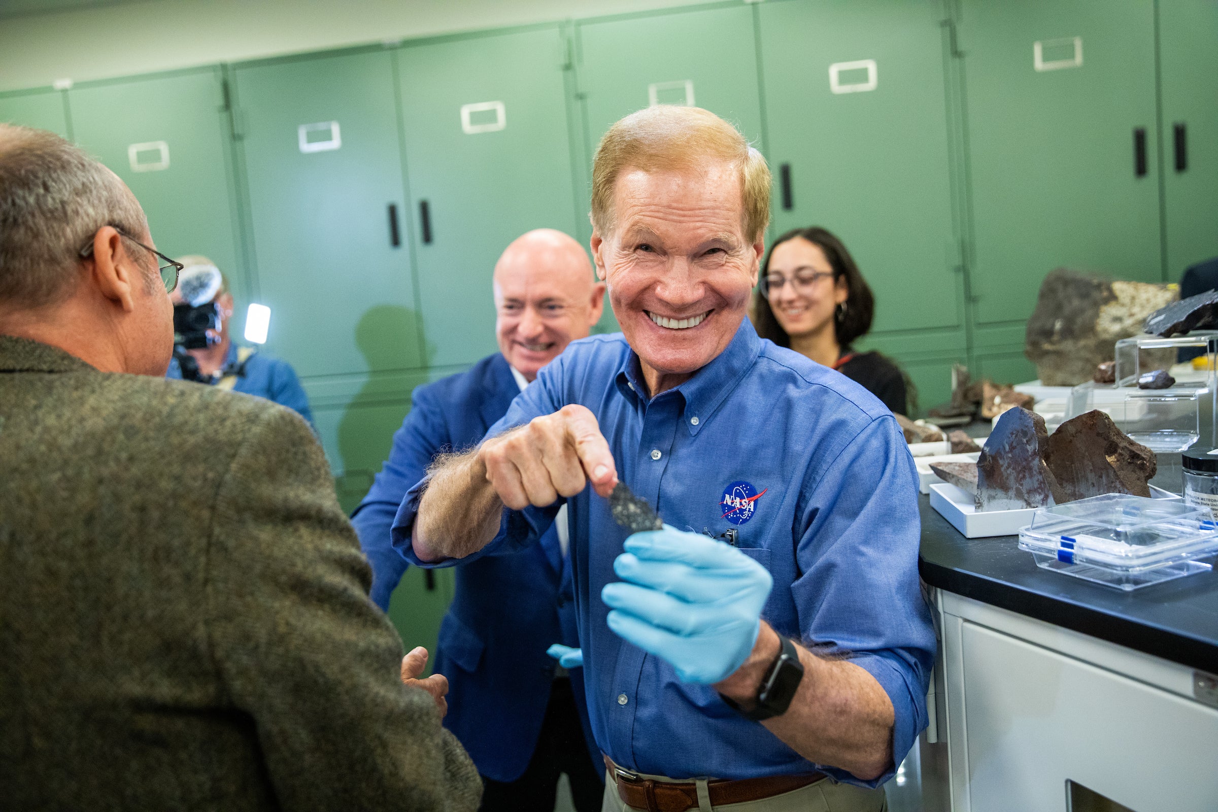 A man smiles as he holds a meteorite