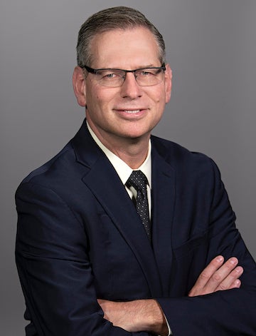 Man in glasses and suit smiling