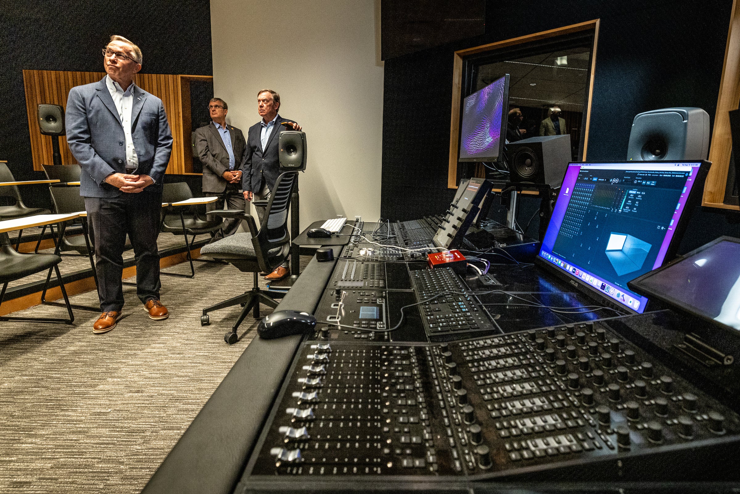 Three men touring a studio room