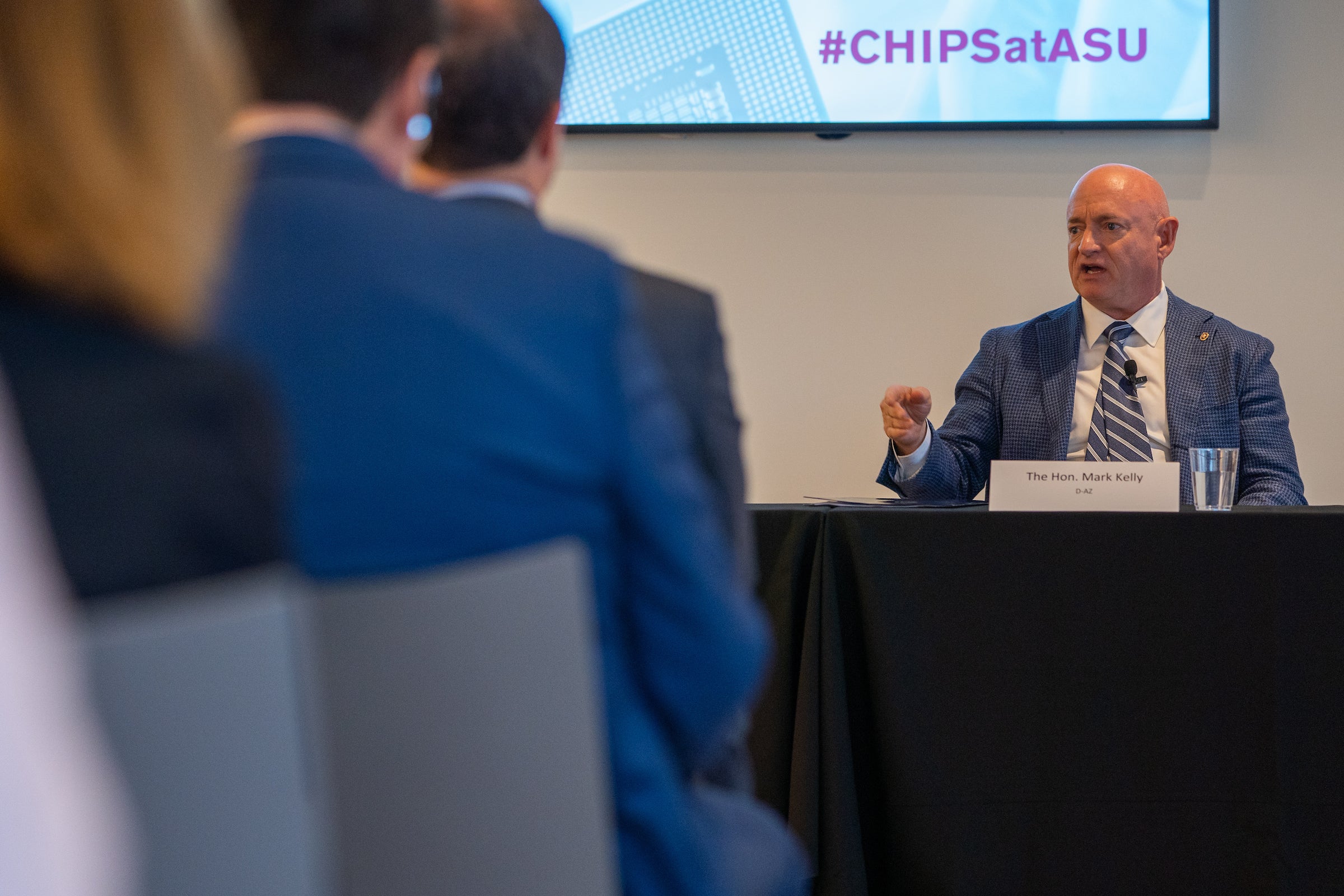 View of man behind table speaking at event