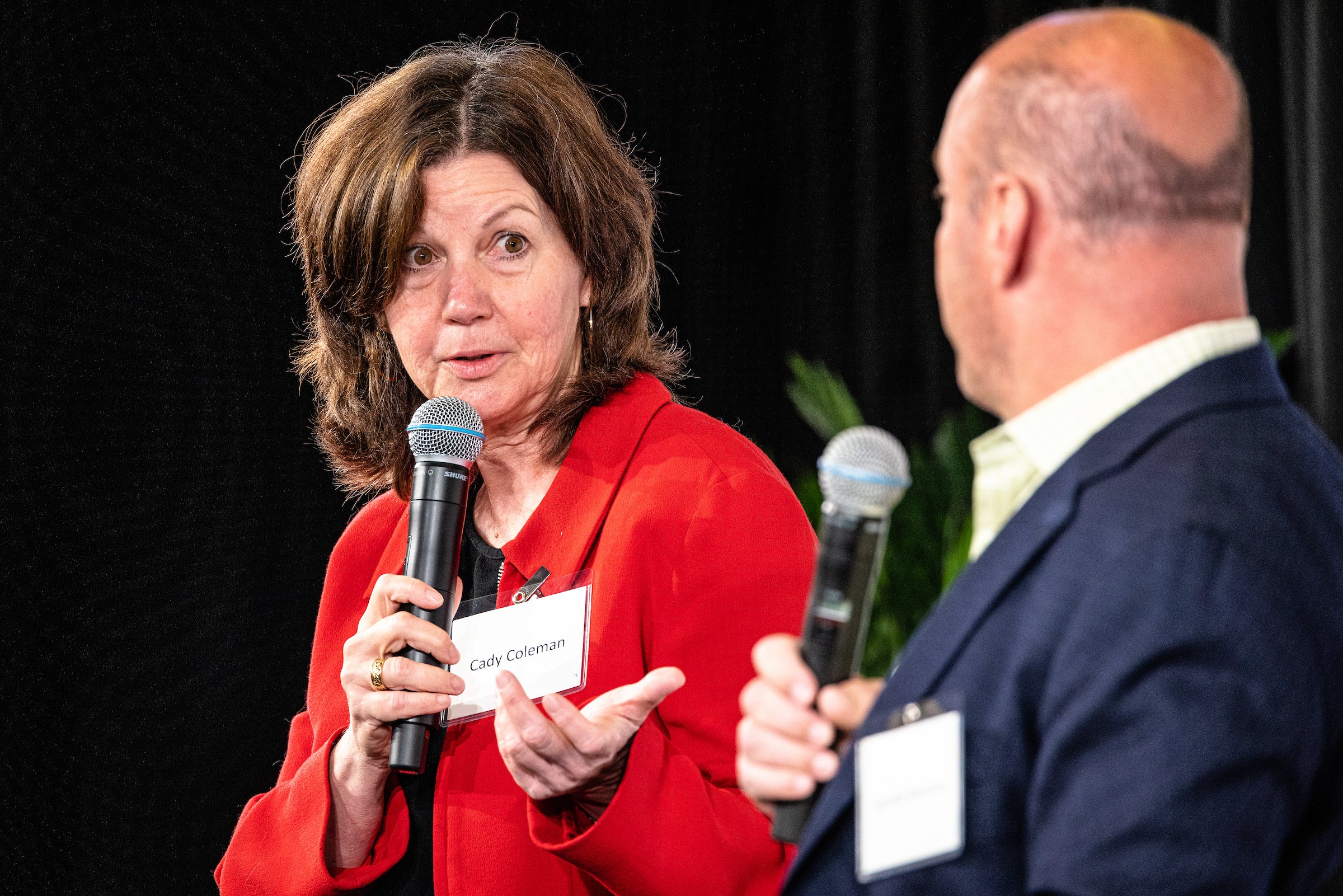 Woman speaking to moderator on stage