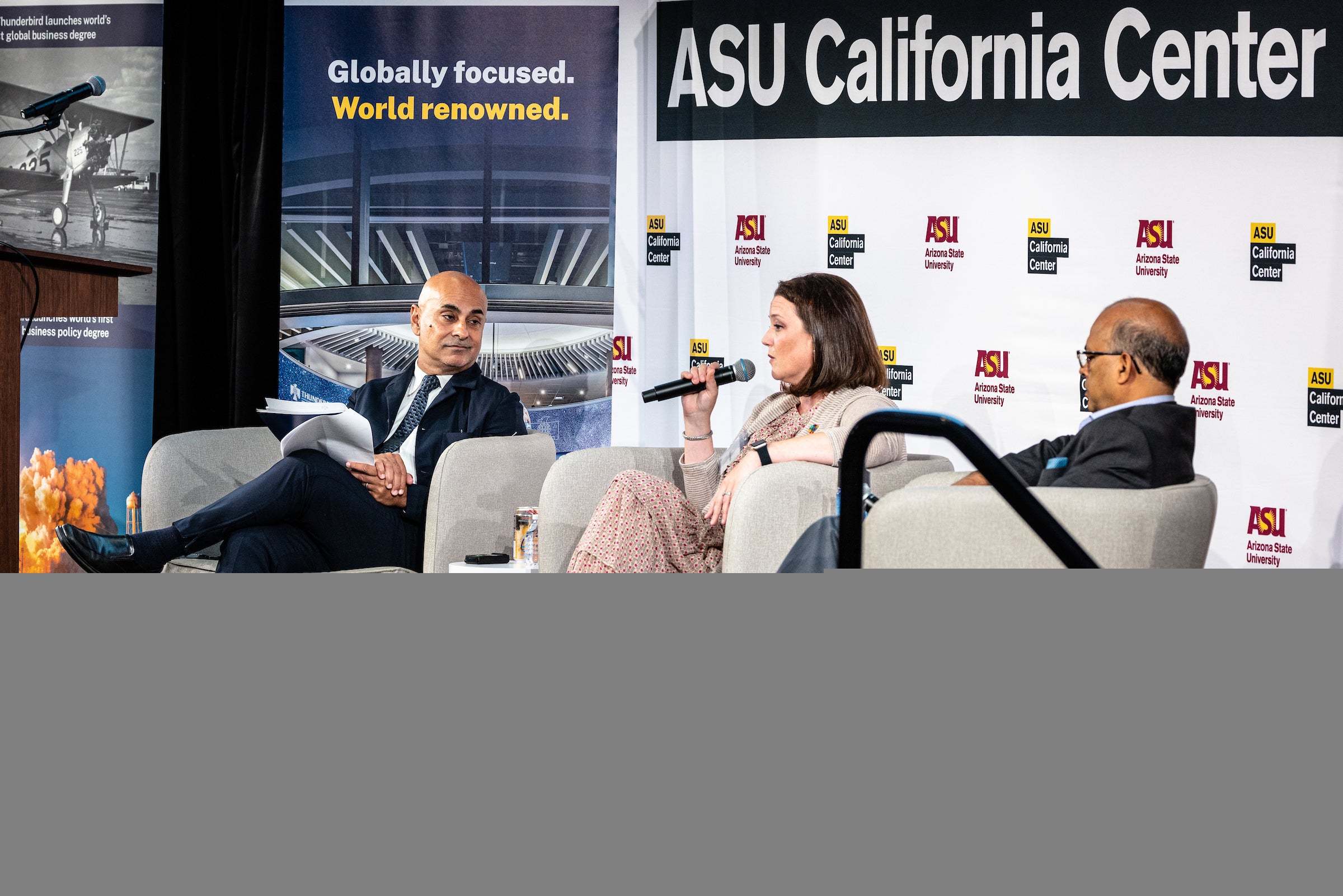 Two men and a woman sit on a stage with mics and a sign behind them that says ASU California Center