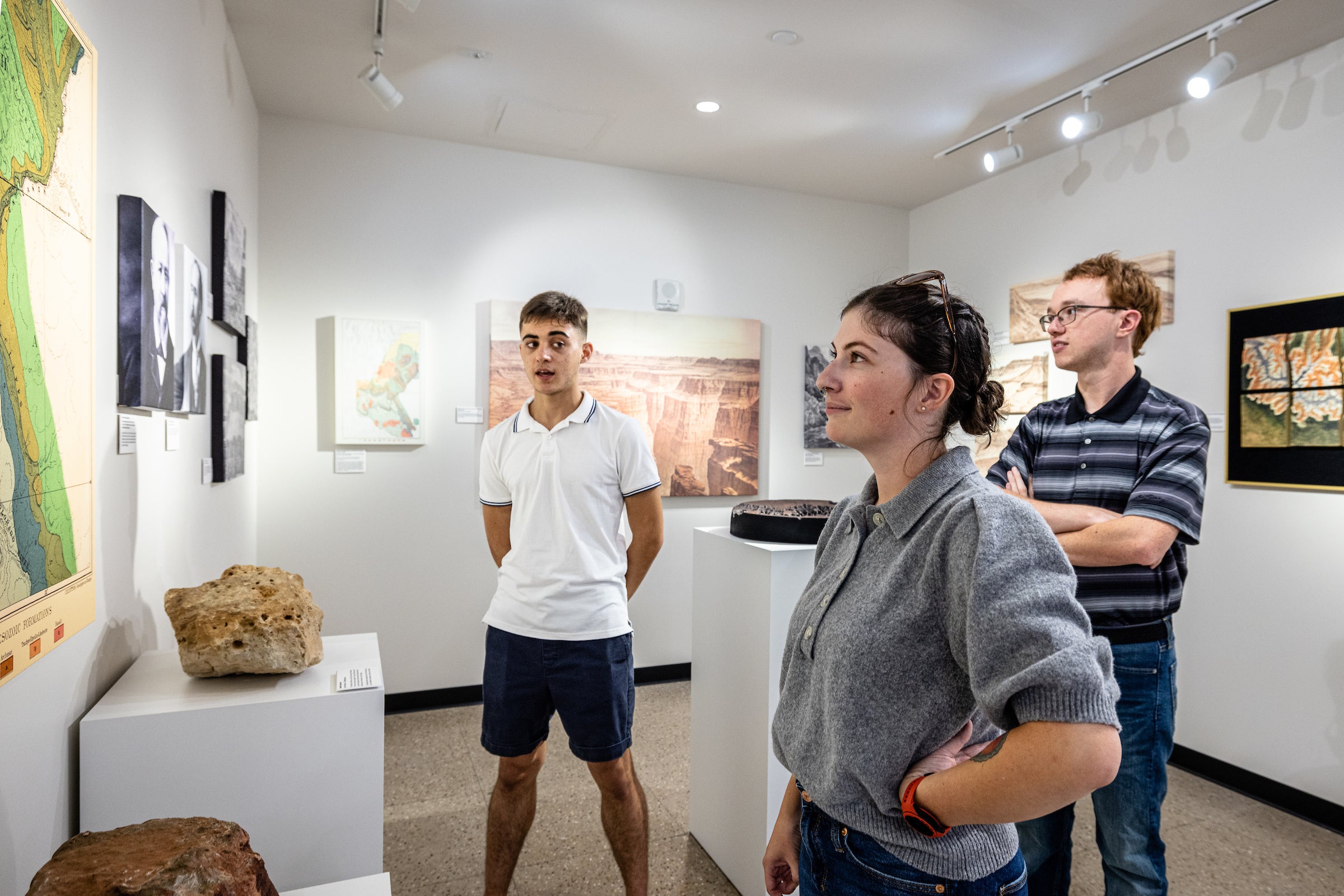 Three people examining exhibit