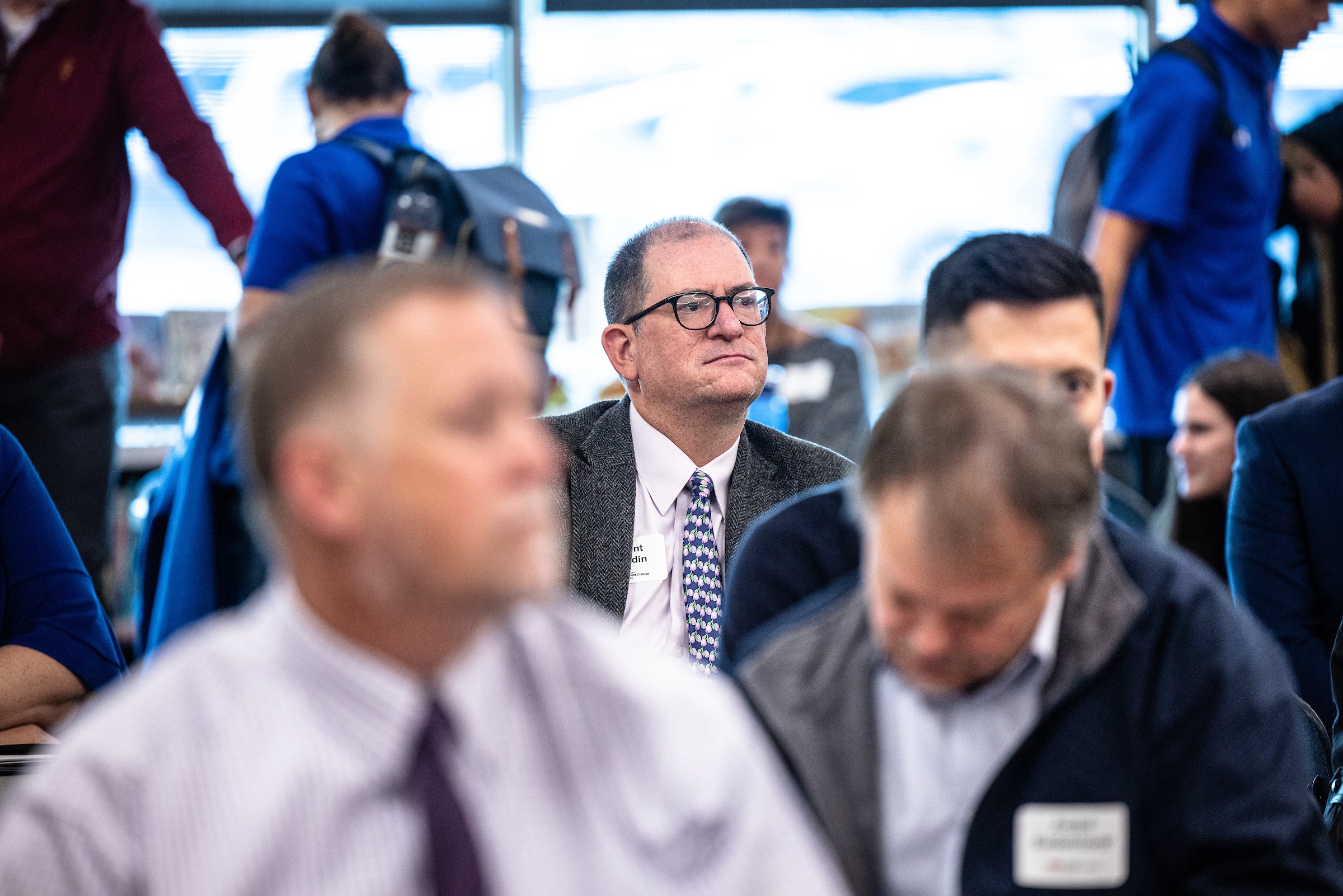 Man in crowd listening to presentation