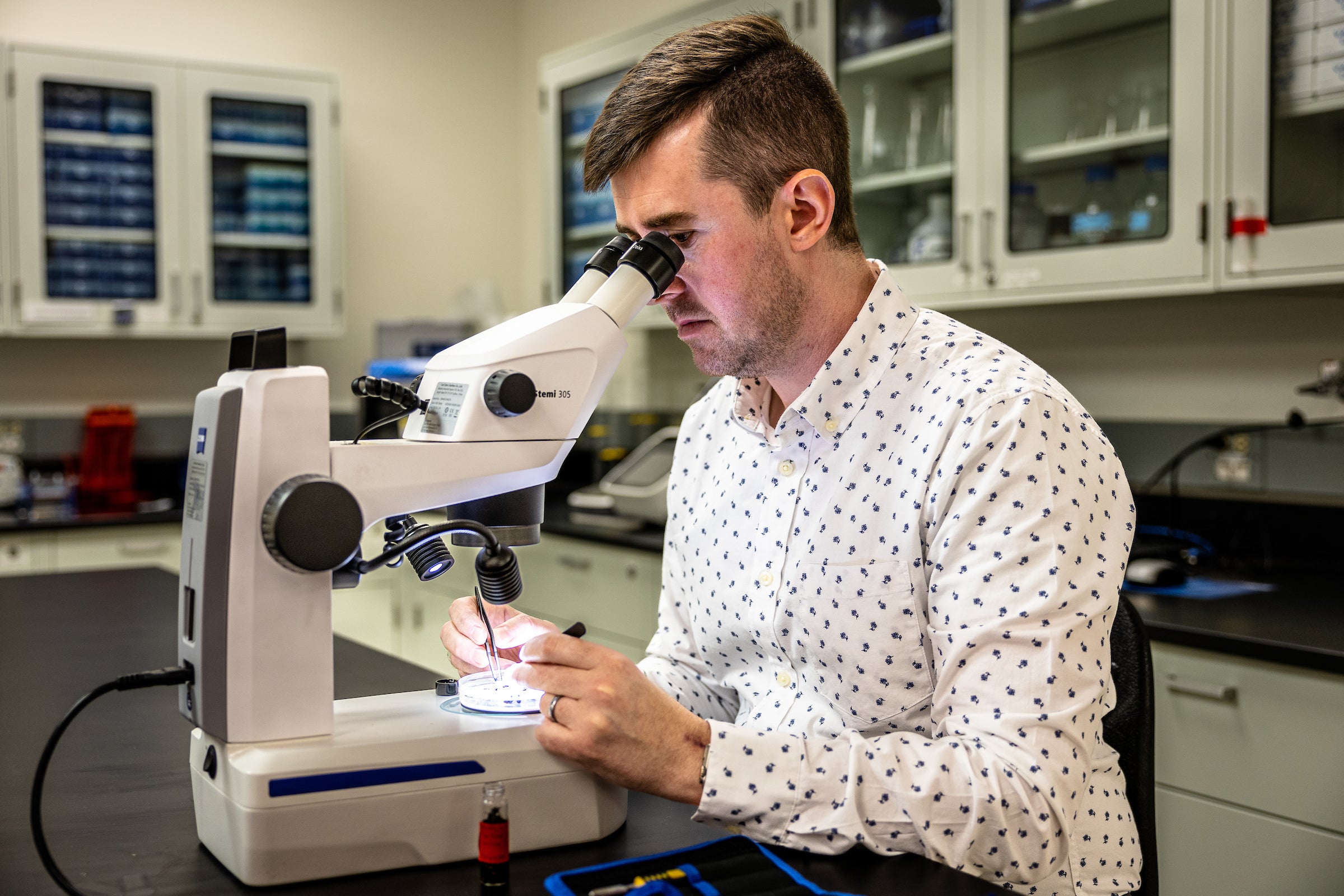 man looking through microscope