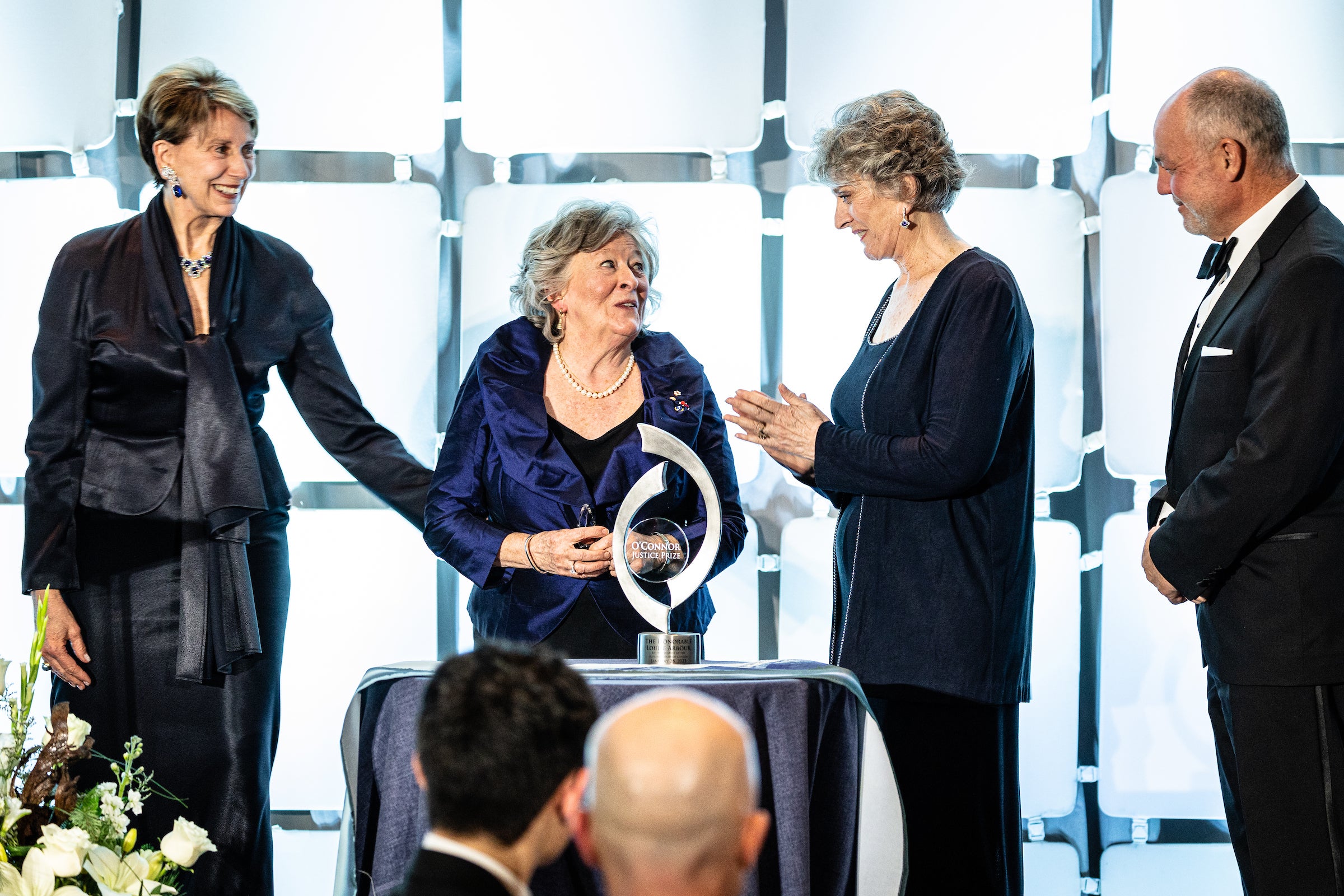 People greeting Louise Arbor on stage to receive prize