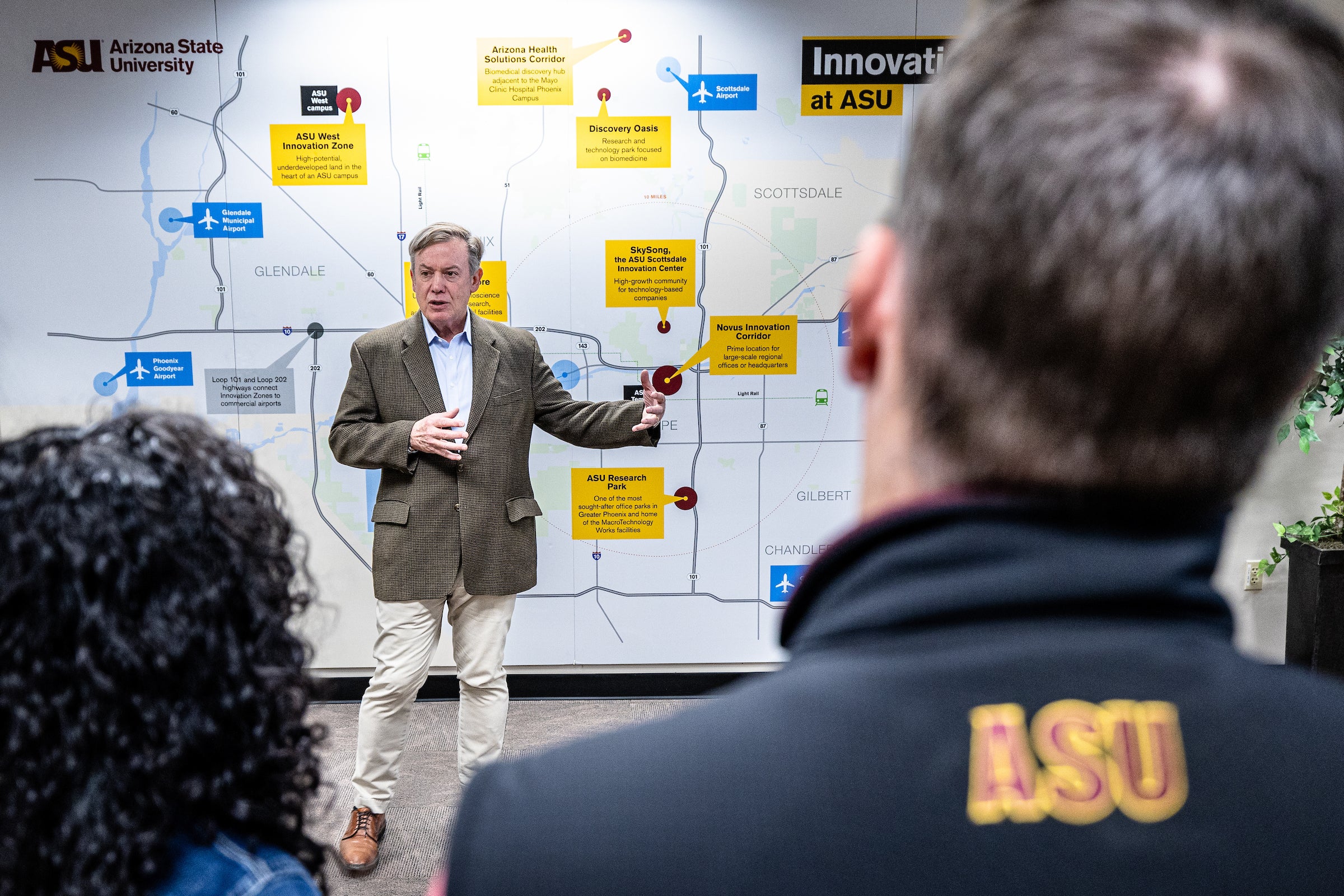 Man talking to group while standing in front of large map of Phoenix