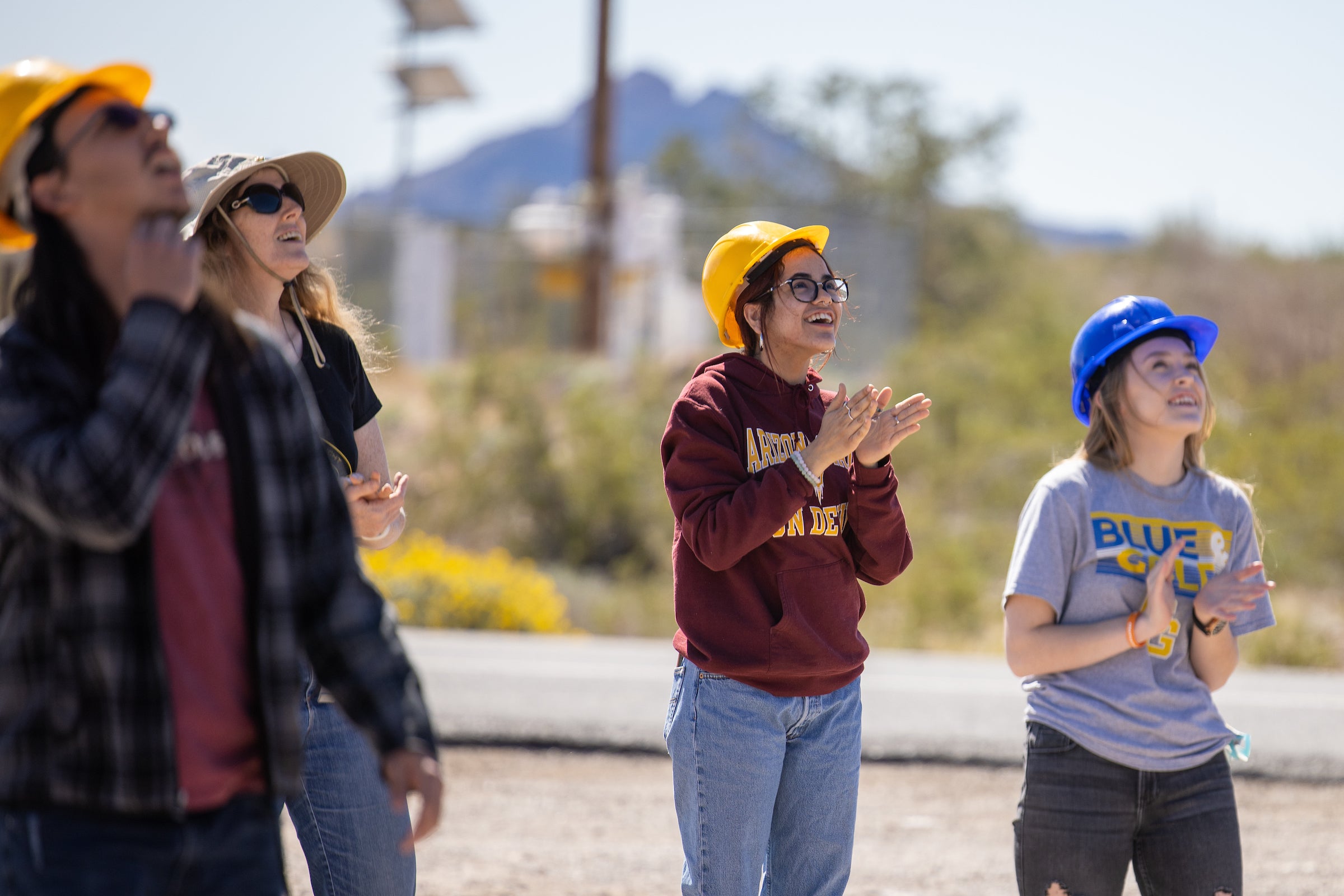 Students look to the sky as a weather balloon takes off