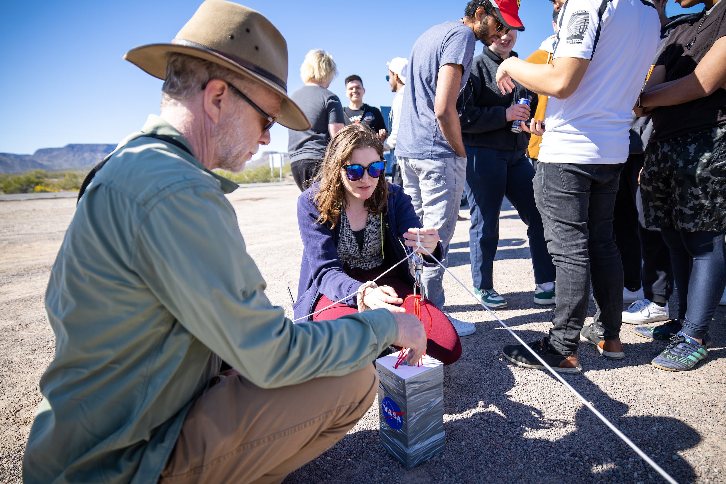 Man and female student set up payload for weather balloon.