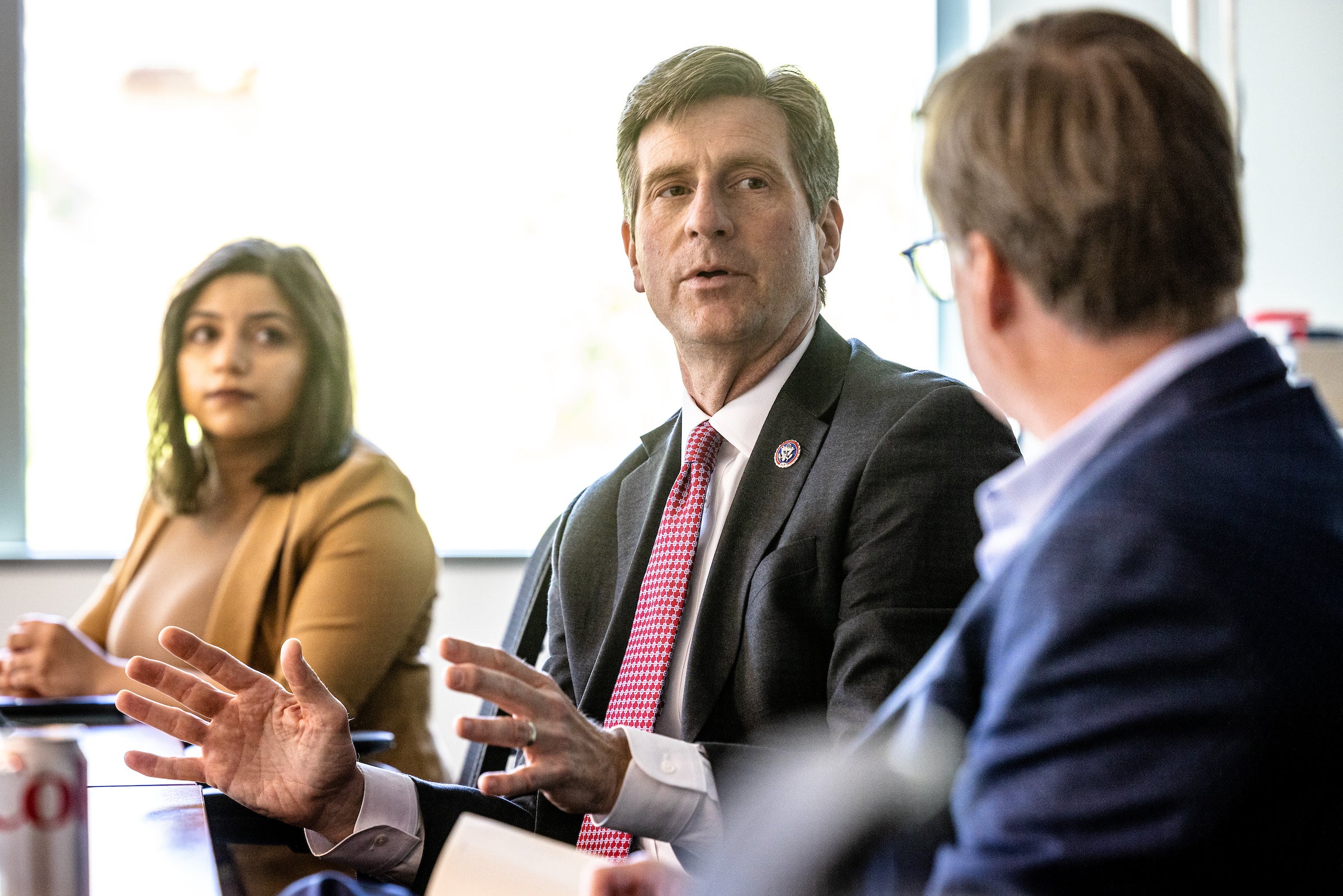 Three people sitting at conference table talking