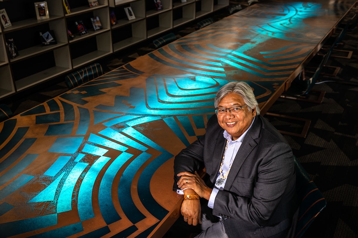 Jacob Moore sitting at a table with a bright blue and brown tribal design.