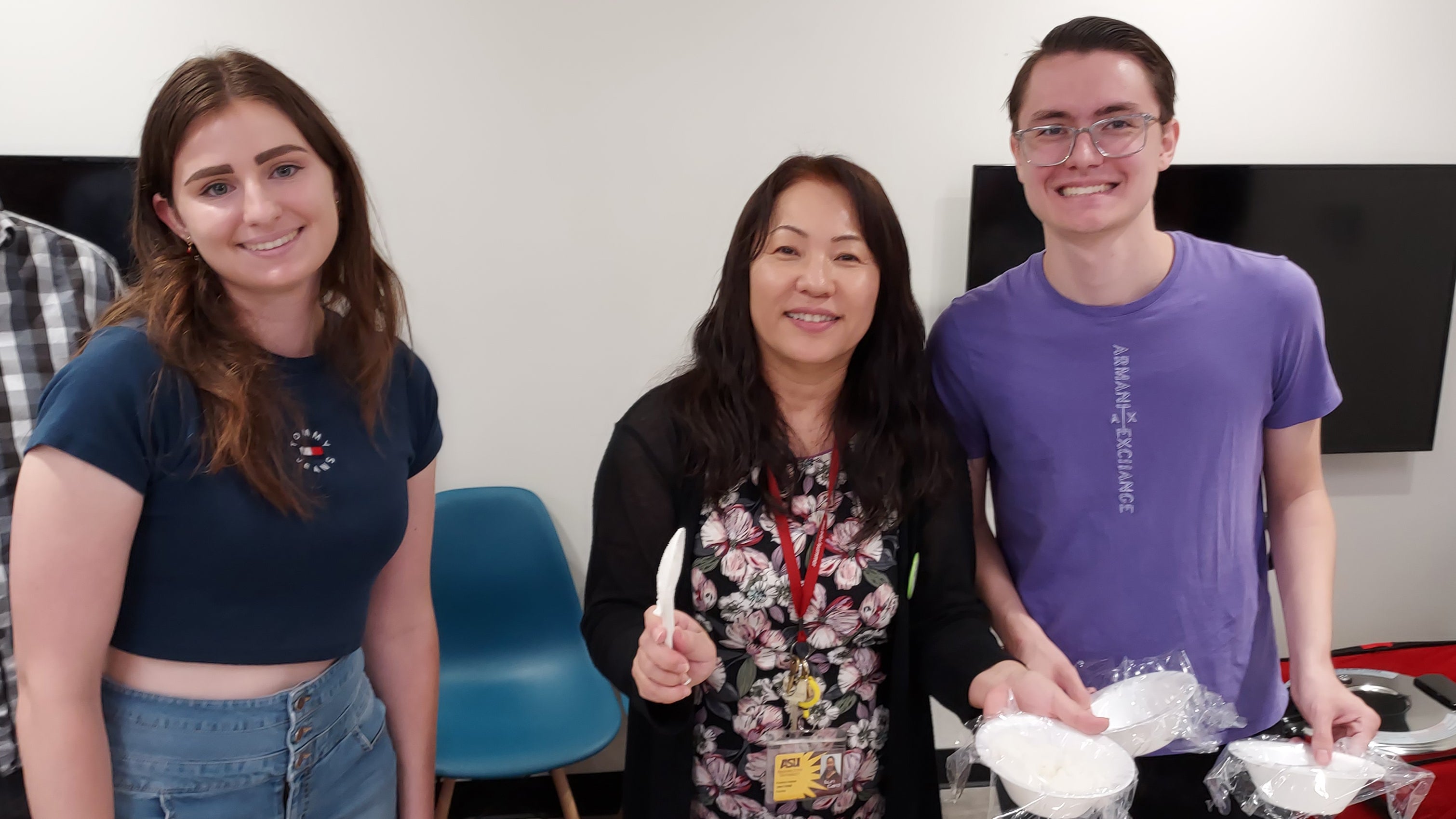 Professor in middle and two students smiling