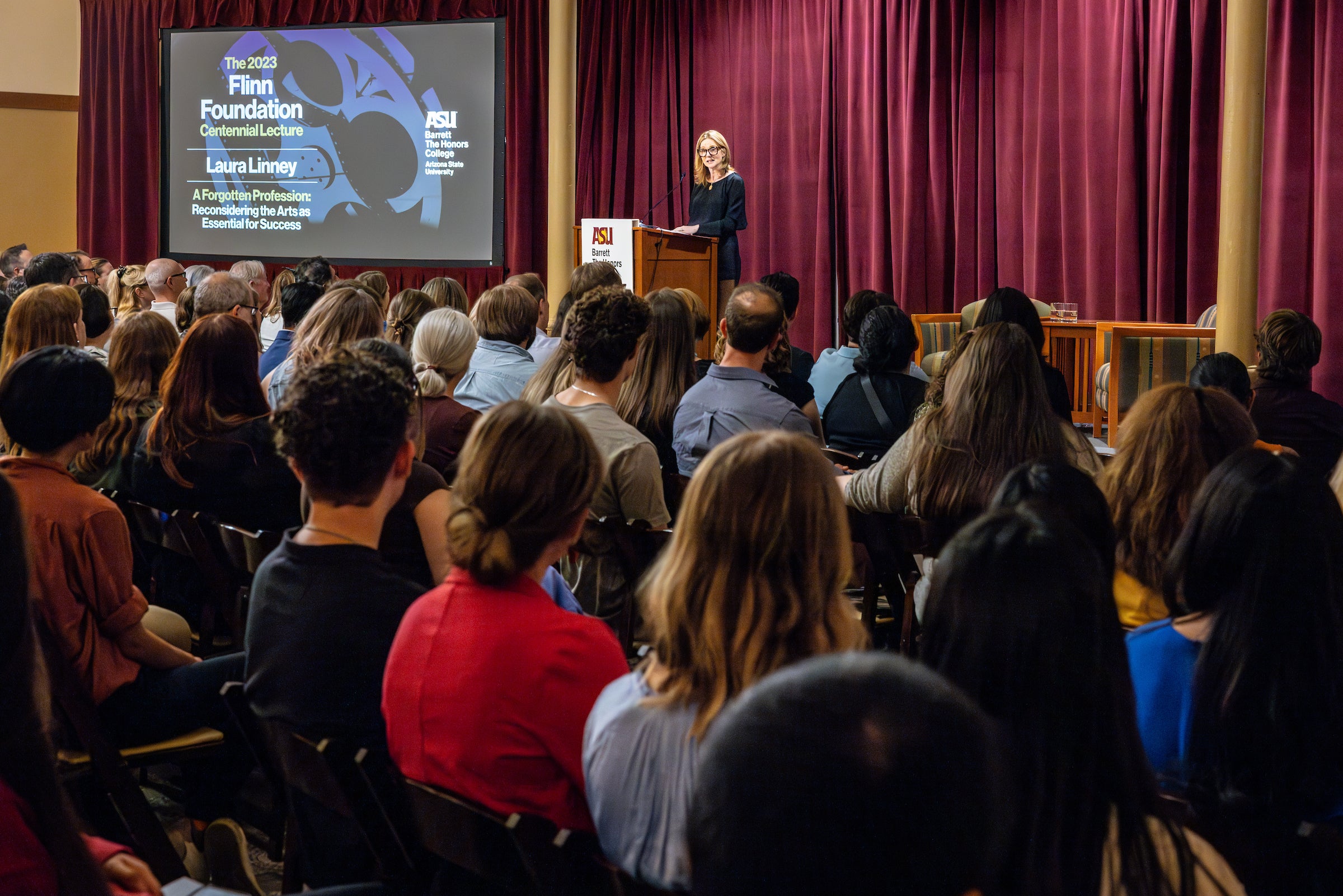 Audience members watching Laura Linney give lecture