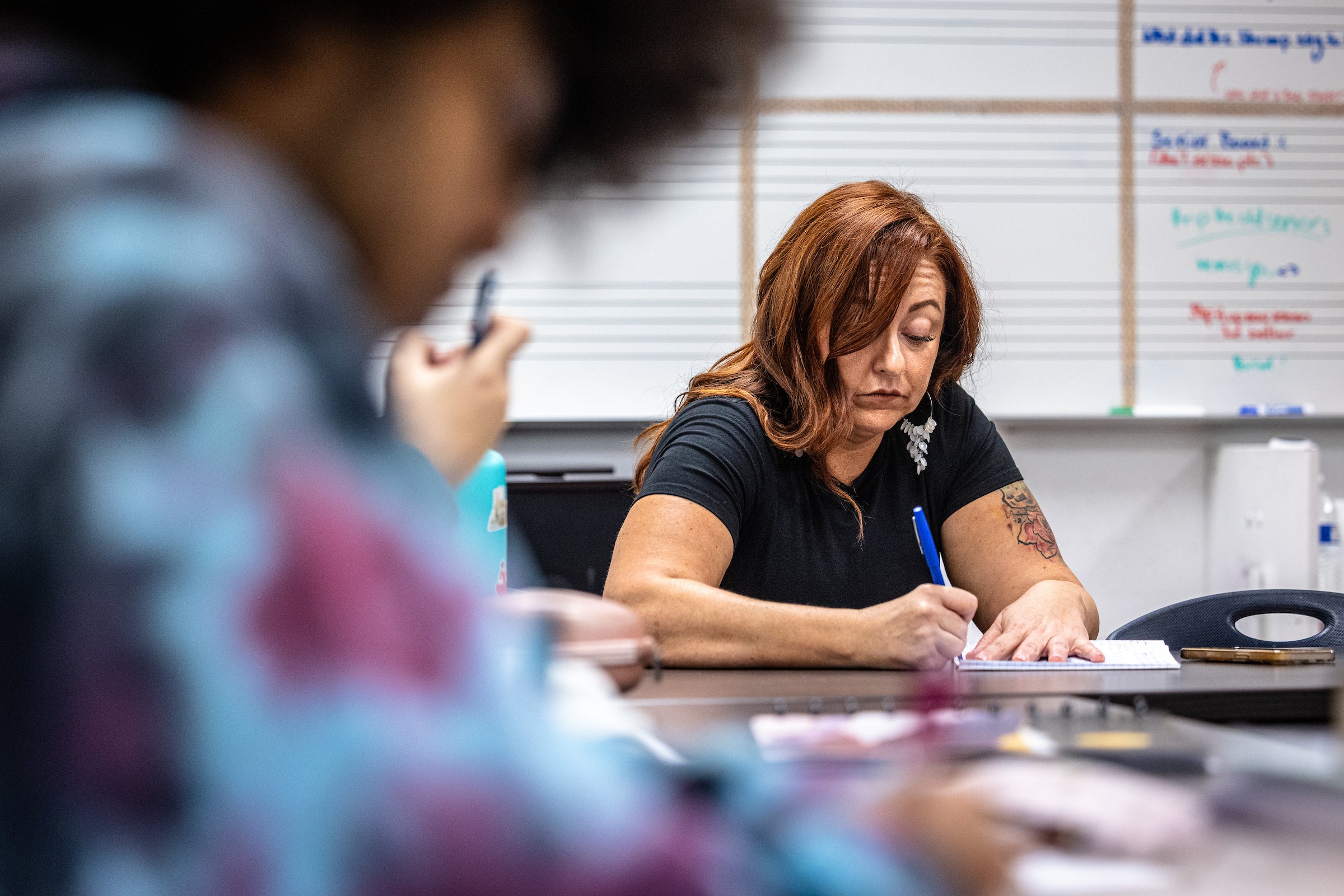 High school teacher writing during class