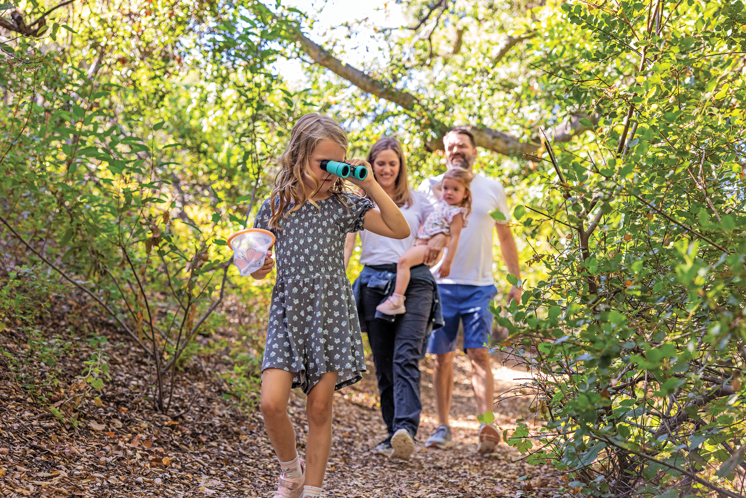 Family of four walking through a trail in the woods 