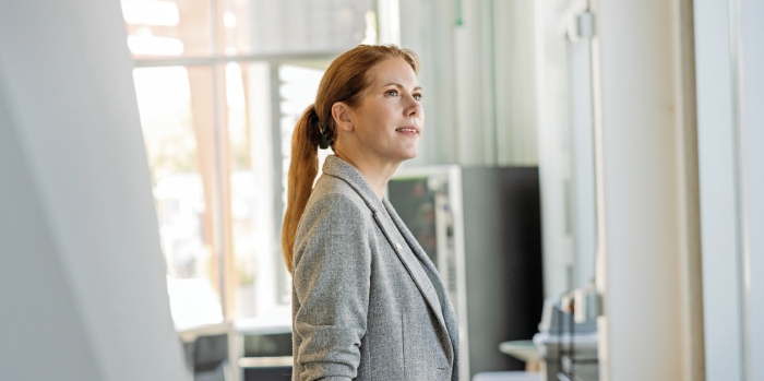 Portrait of a woman with reddish brown hair wearing a gray blazer 