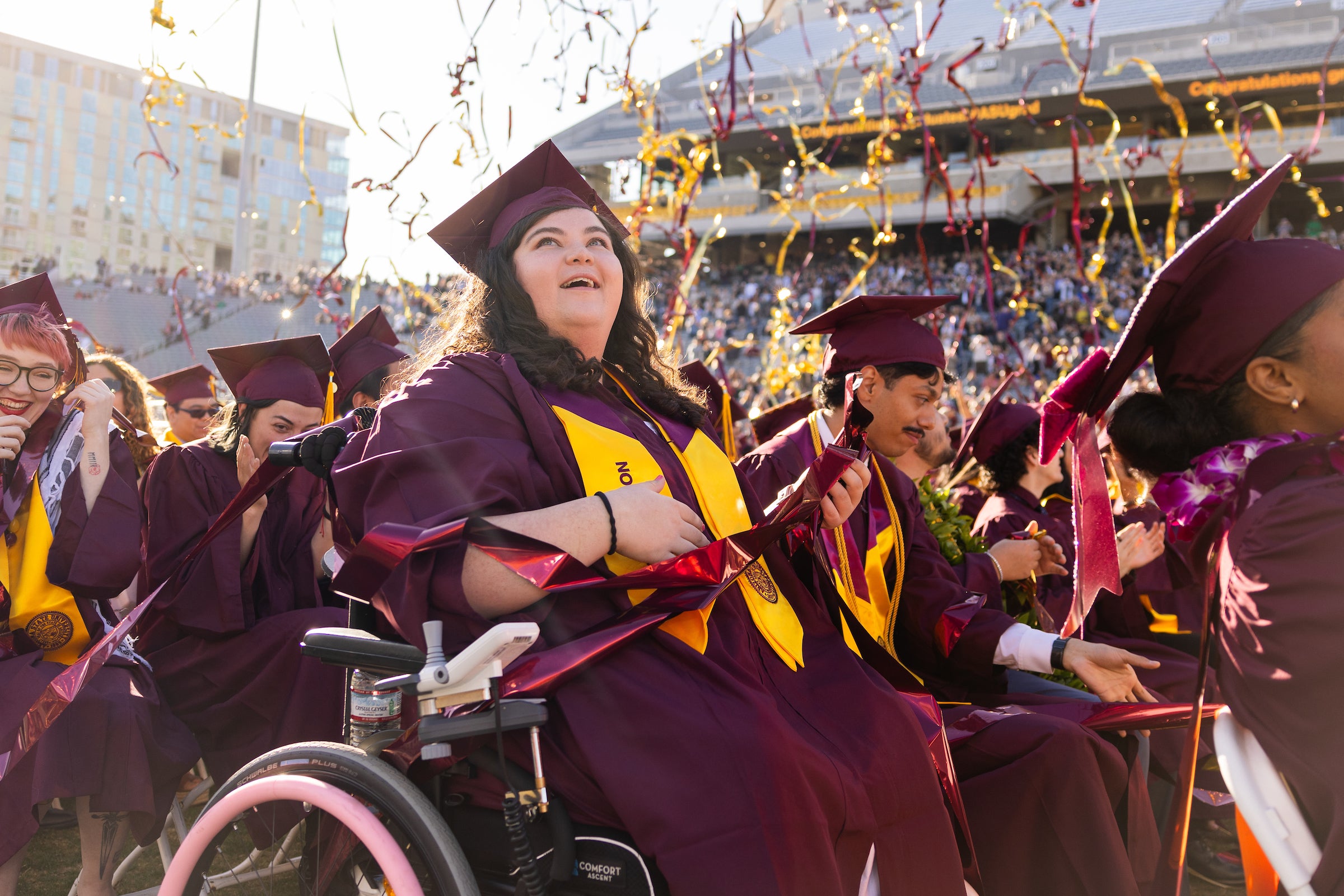 A graduate celebrates as streamers fall down at the end of the ceremony