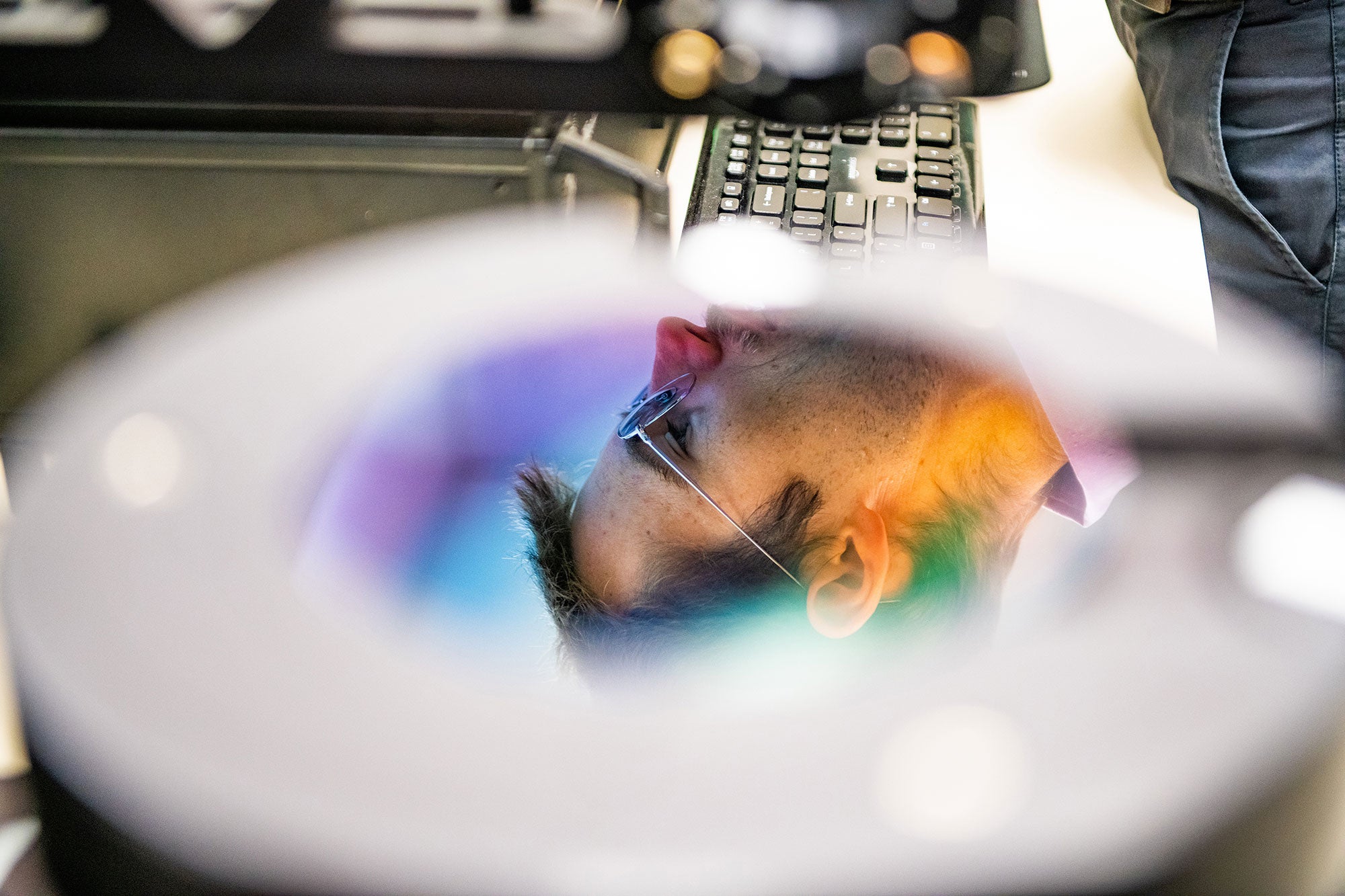 A man's face is seen reflected in a computer chip